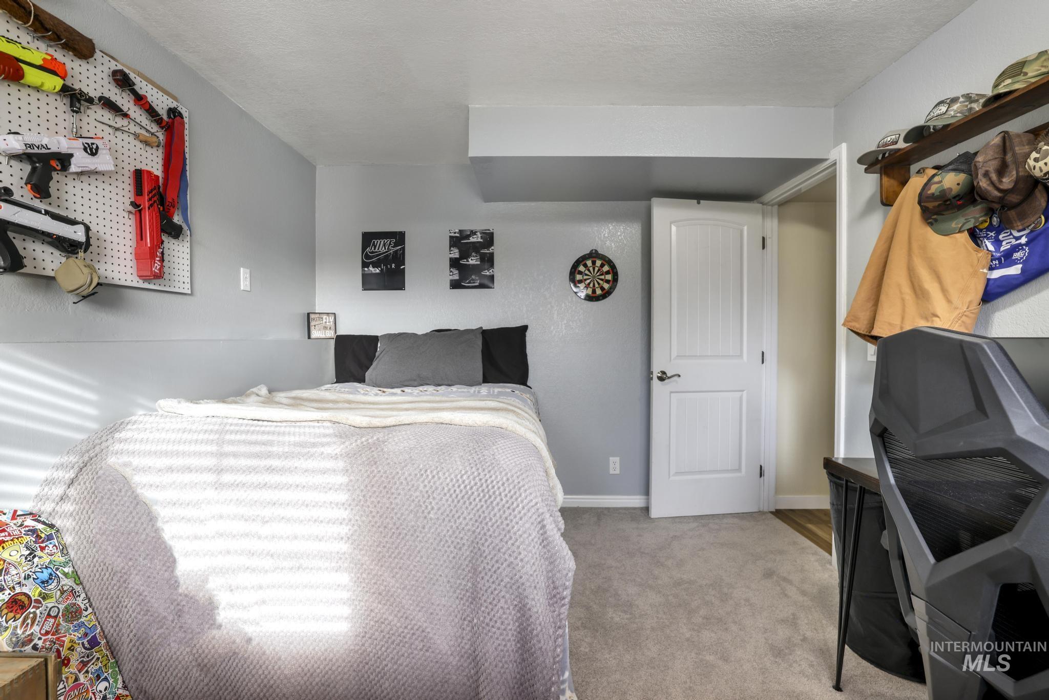 Carpeted bedroom featuring baseboards and a textured ceiling
