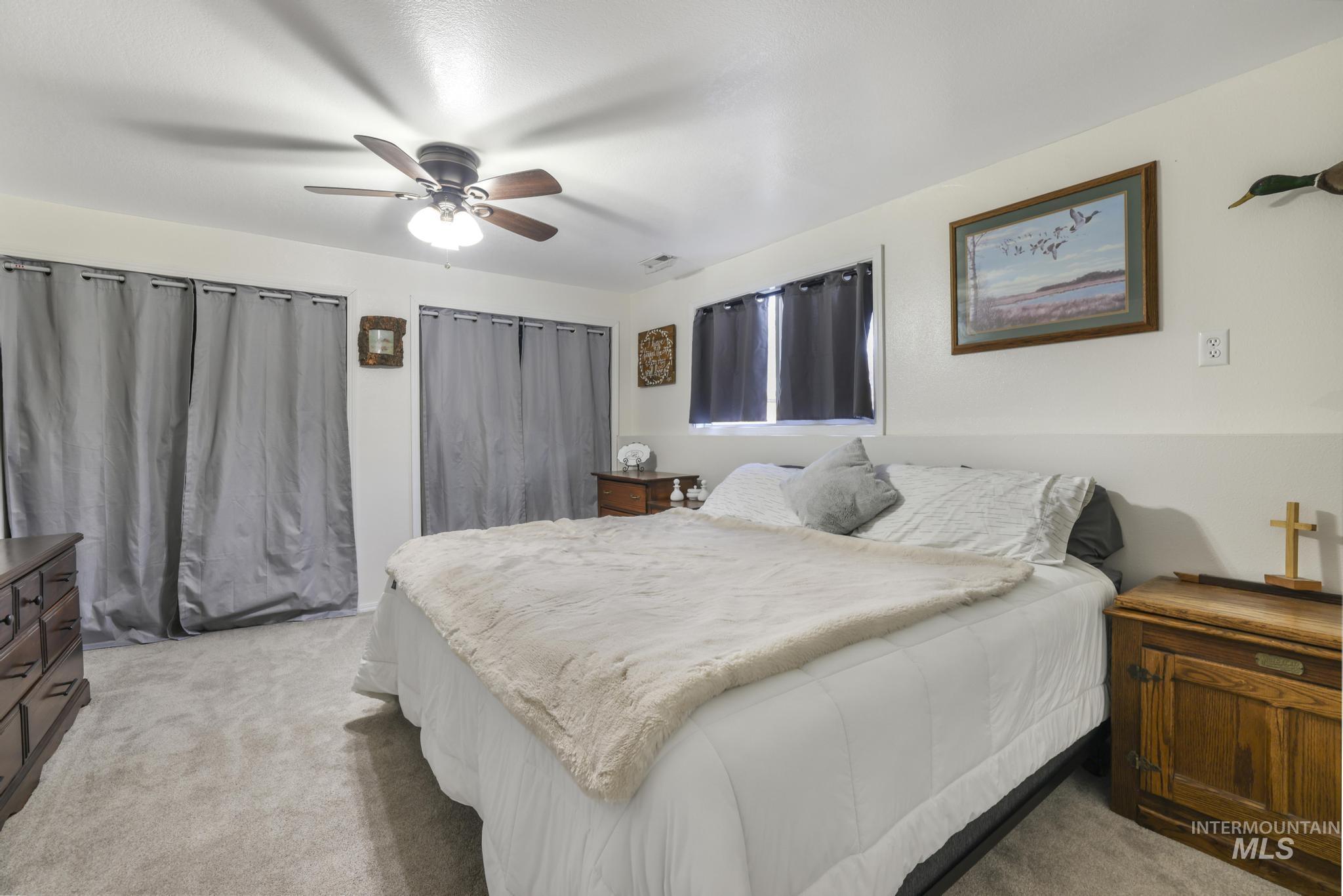 Bedroom featuring light colored carpet and a ceiling fan