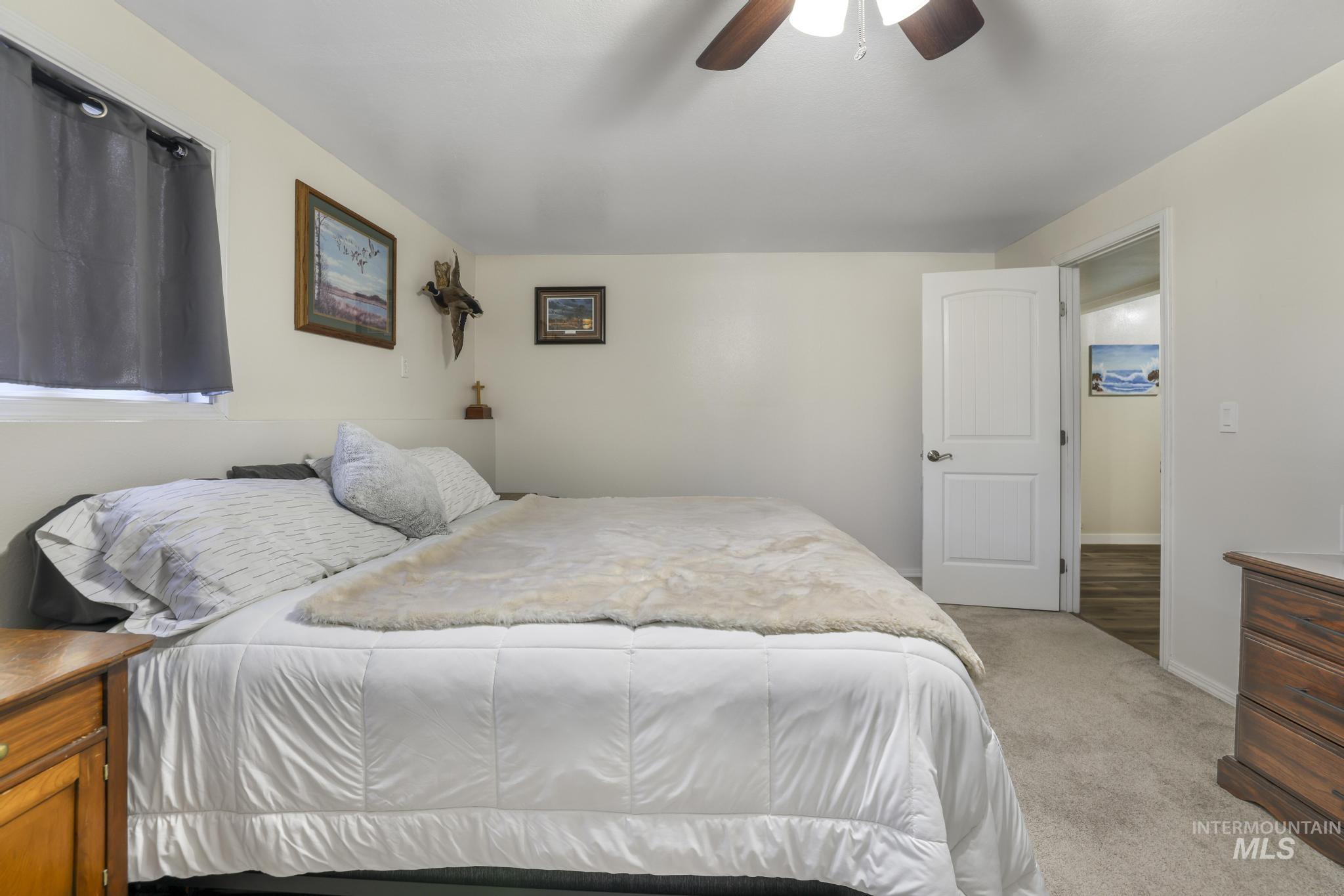 Bedroom featuring light carpet and a ceiling fan