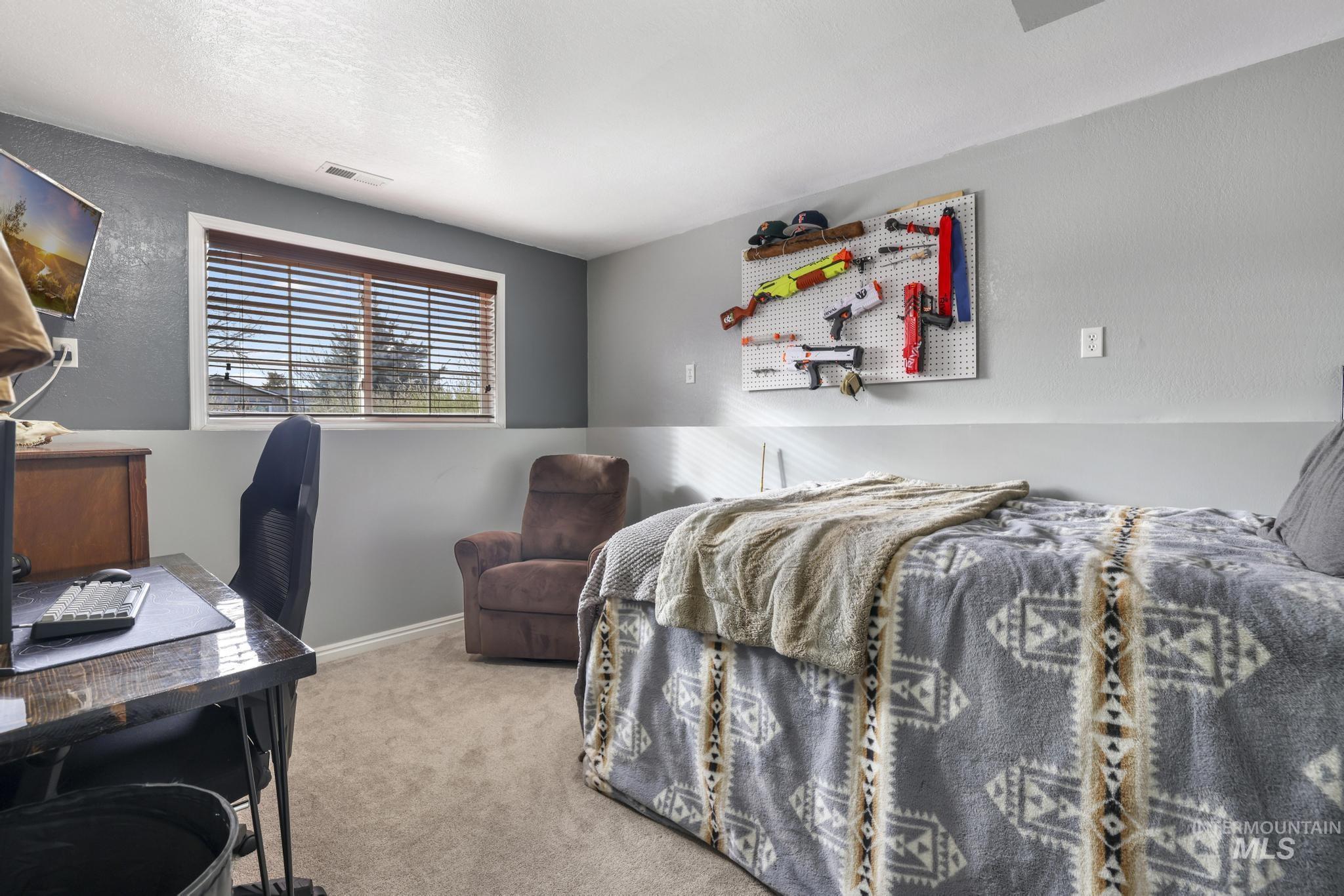 Bedroom featuring an office area and light carpet