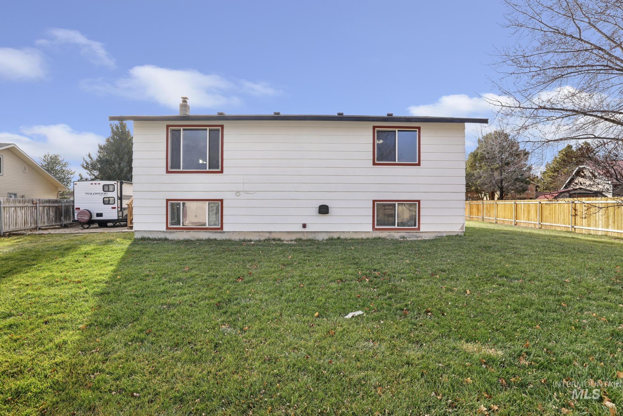 Rear view of house with a fenced backyard