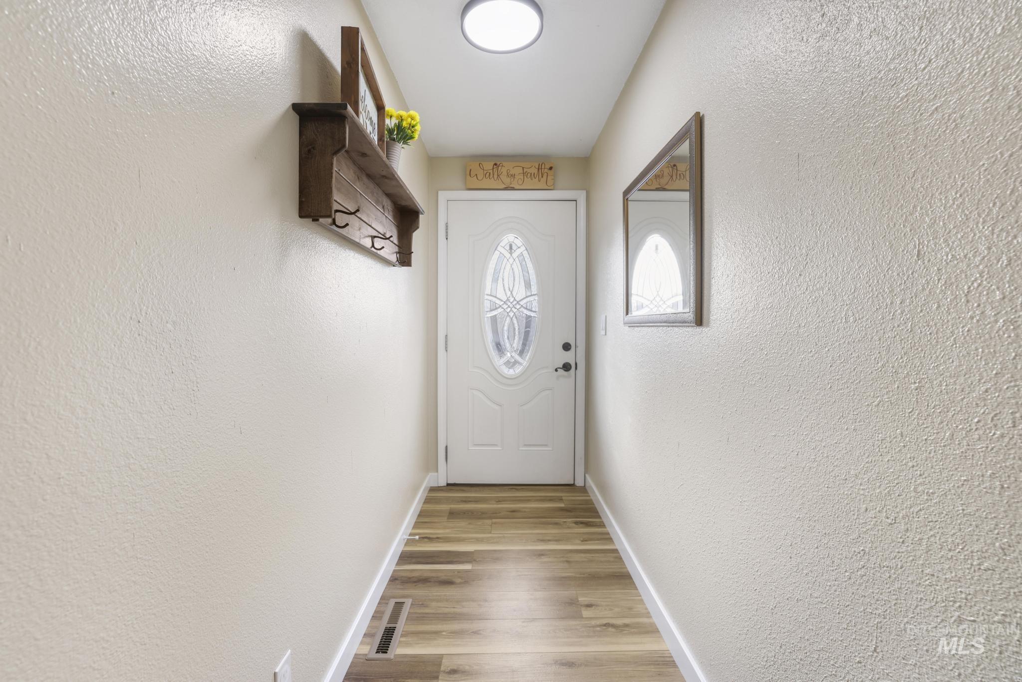 Entryway featuring a textured wall and wood finished floors