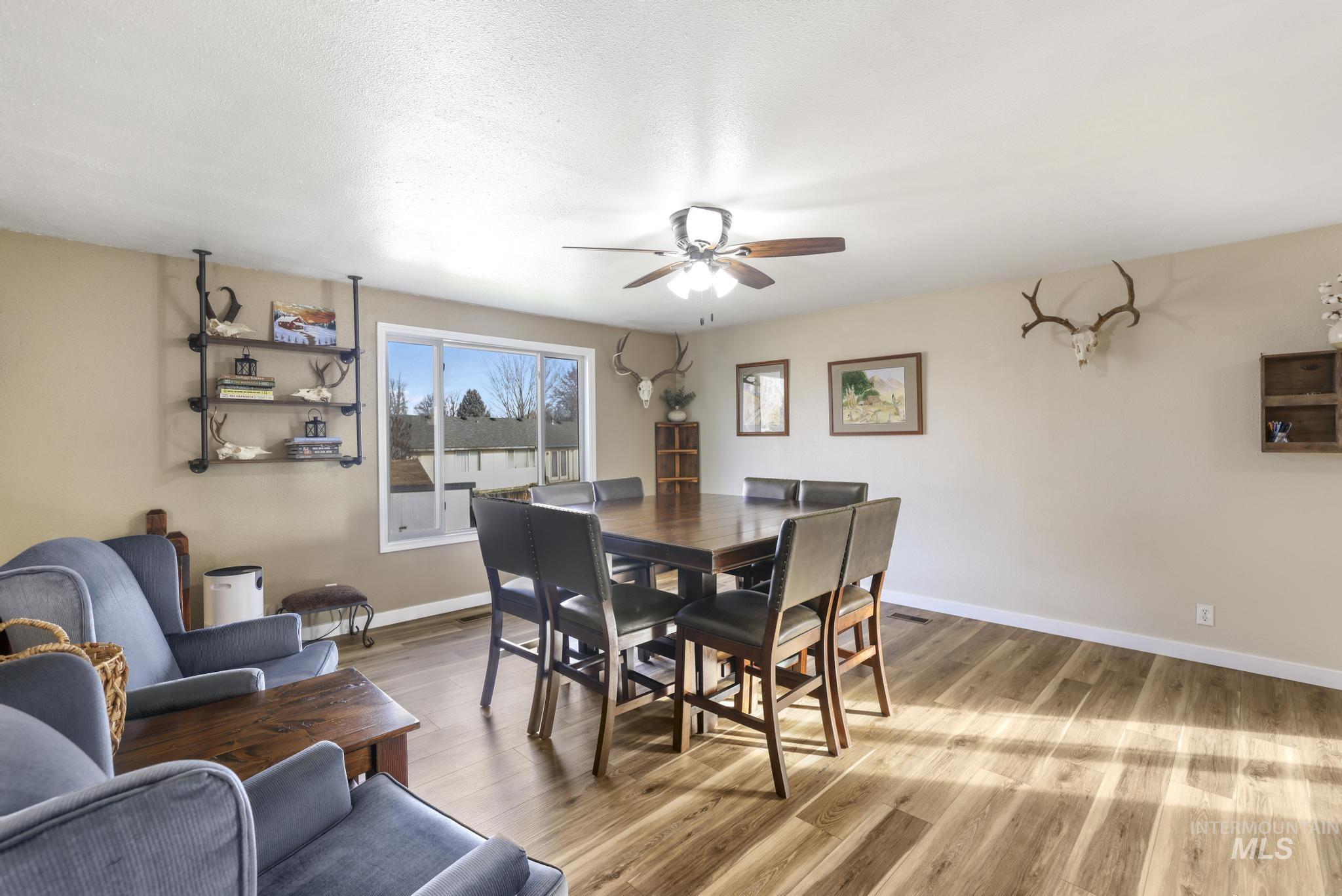 Dining space featuring light wood-style floors, a ceiling fan, and a textured ceiling