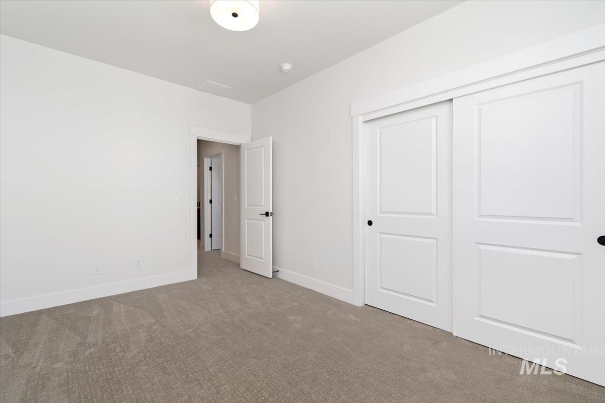 Unfurnished bedroom featuring carpet flooring and a closet