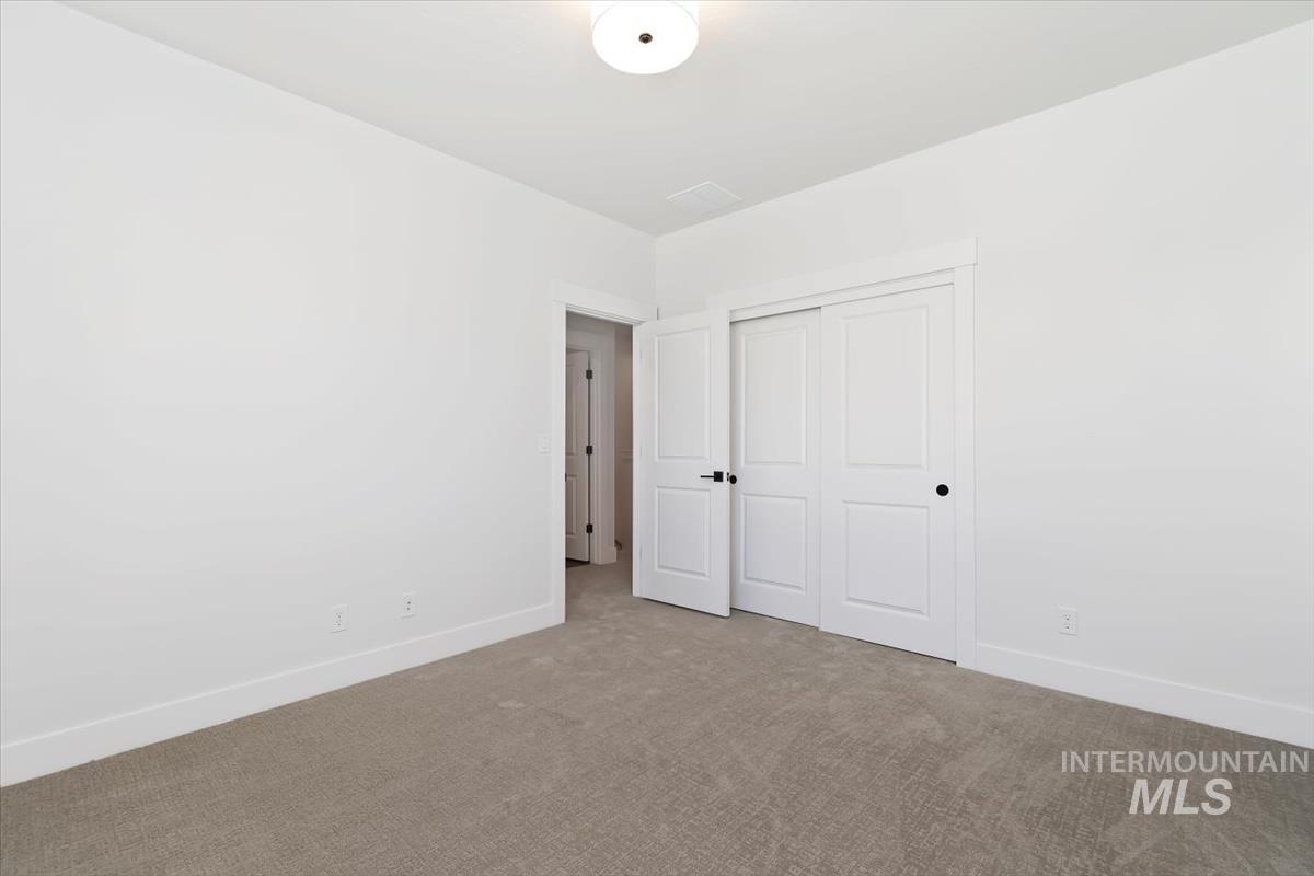Unfurnished bedroom featuring carpet and a closet