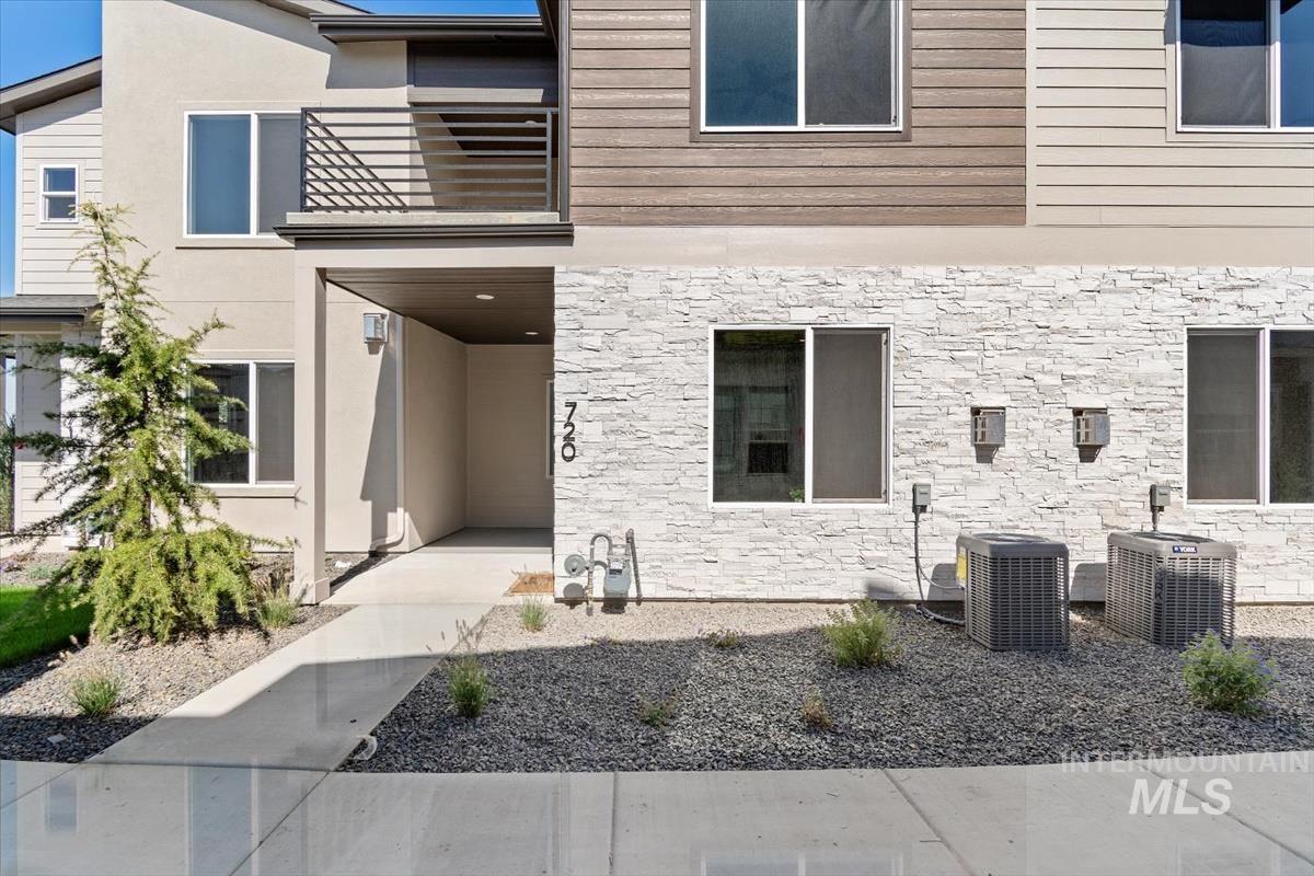 Doorway to property featuring stone siding and stucco siding