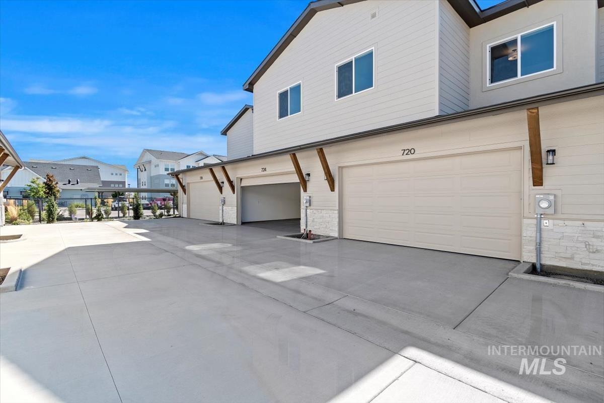 View of home's exterior with stone siding, concrete driveway, and a garage