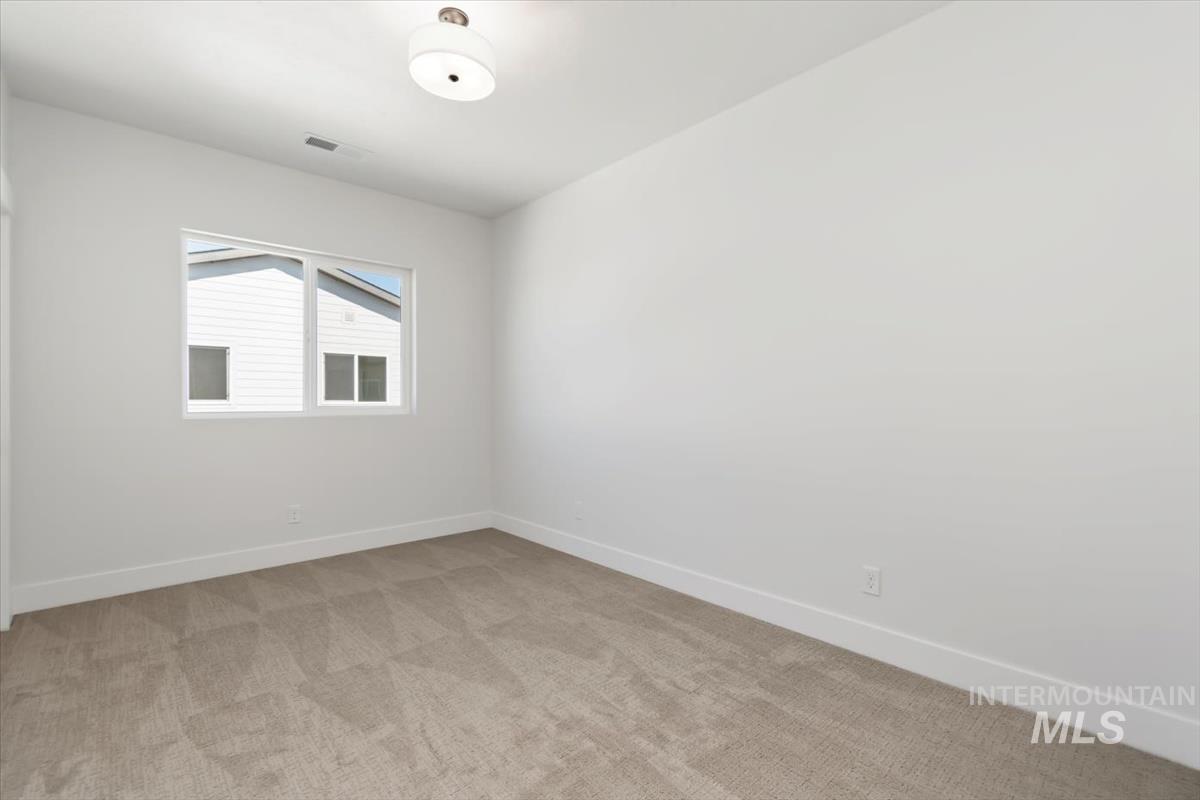 Empty room with baseboards and light carpet