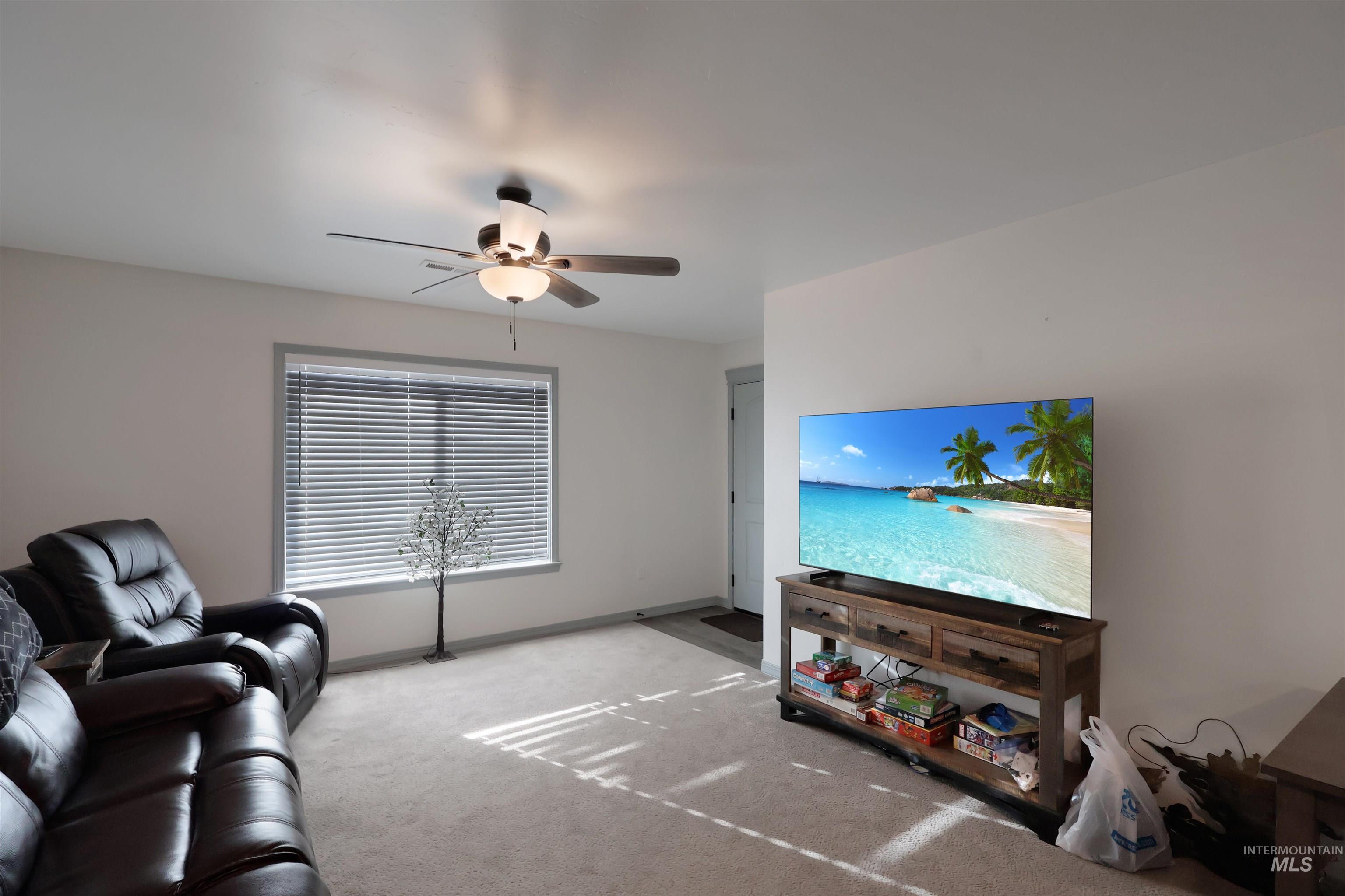 Living room with carpet and ceiling fan