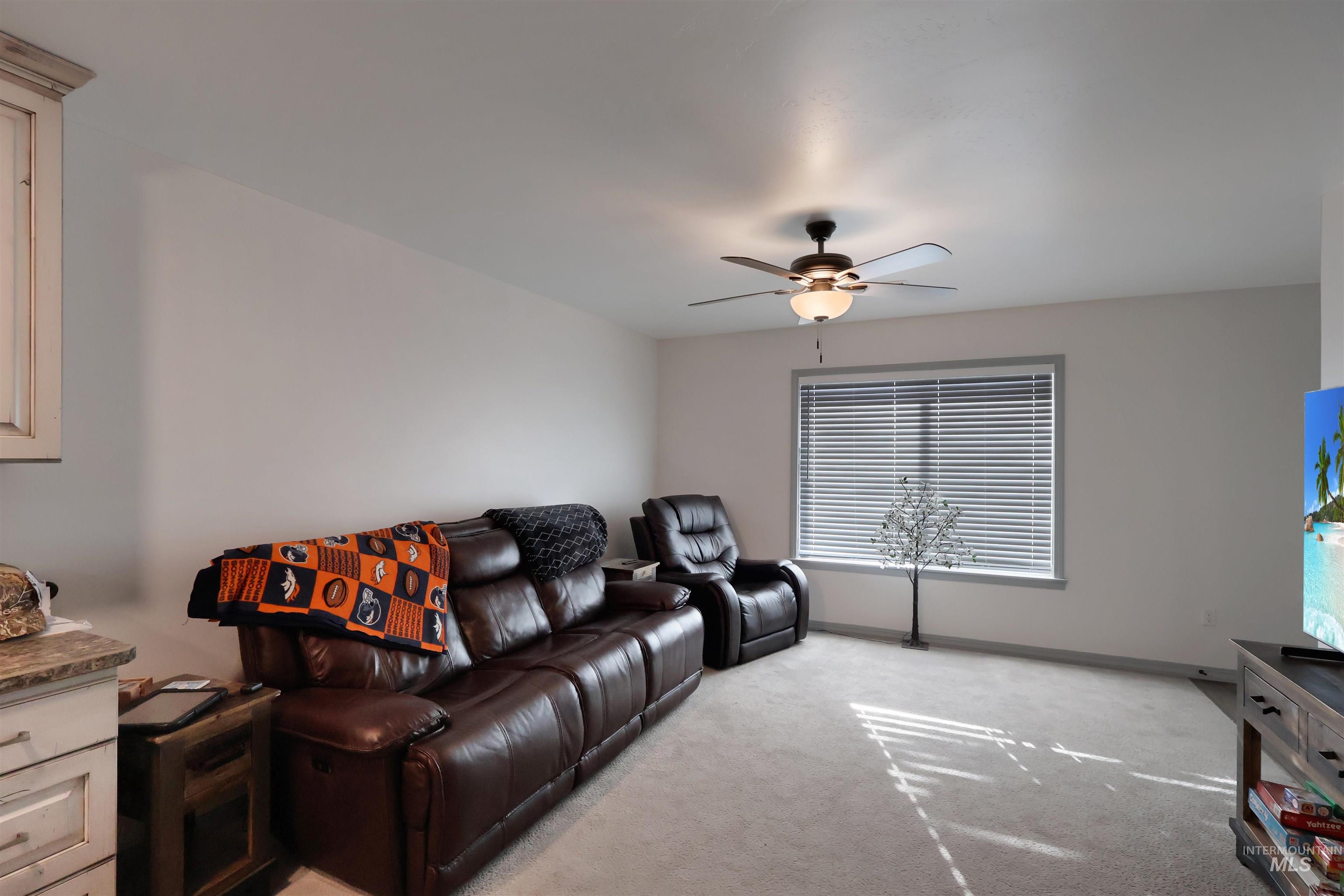 Living room with light carpet and a ceiling fan