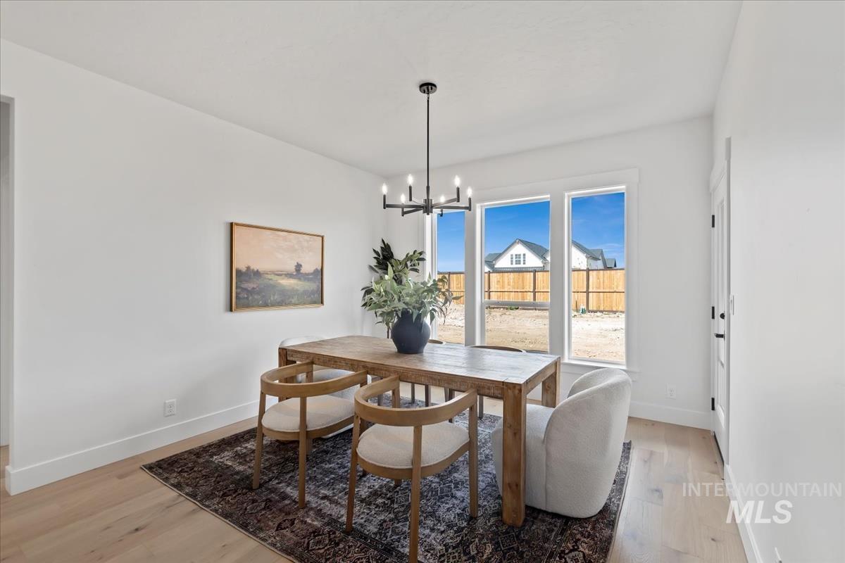 Dining room with light wood-style floors and a chandelier