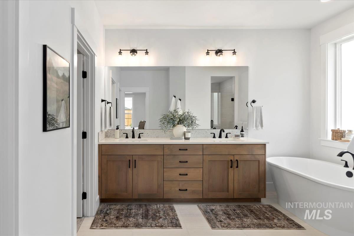 Bathroom featuring a soaking tub, double vanity, and a shower stall