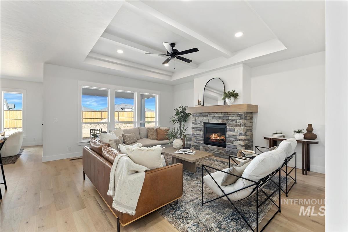 Living area featuring a fireplace, light wood-type flooring, ceiling fan, and recessed lighting