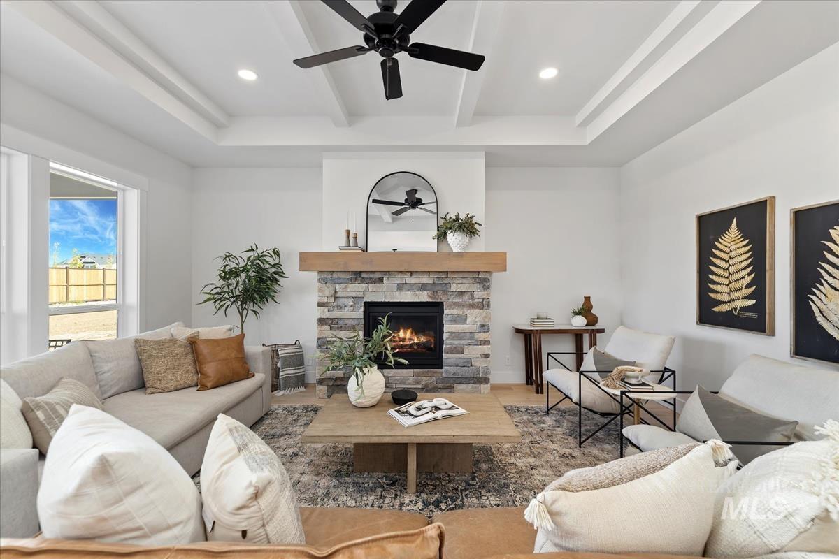 Living area featuring a ceiling fan, a fireplace, beam ceiling, and recessed lighting