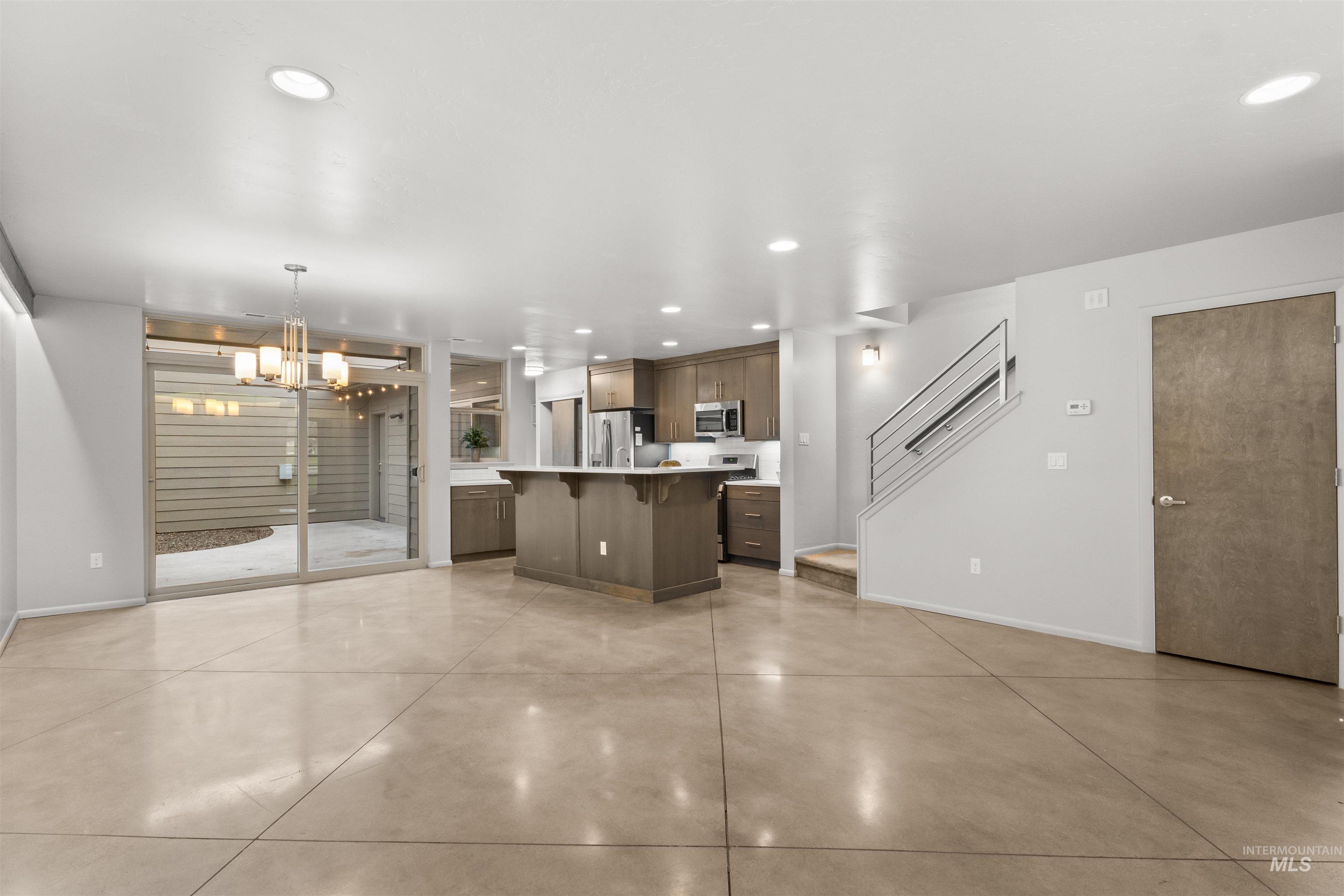 Kitchen featuring light quartz countertops, a breakfast bar, open floor plan, and recessed lighting