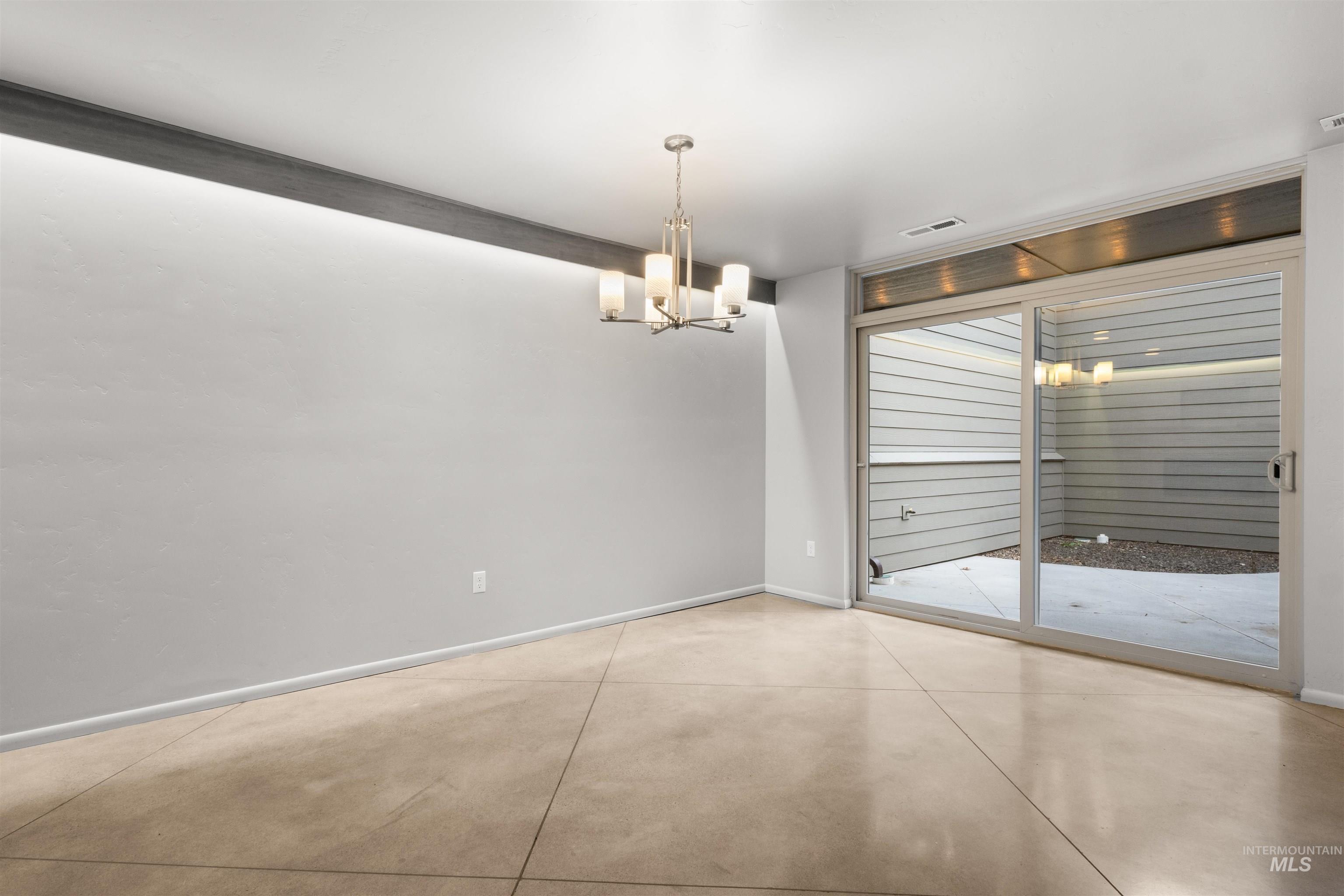 Dining area in the great room with concrete floors and a chandelier