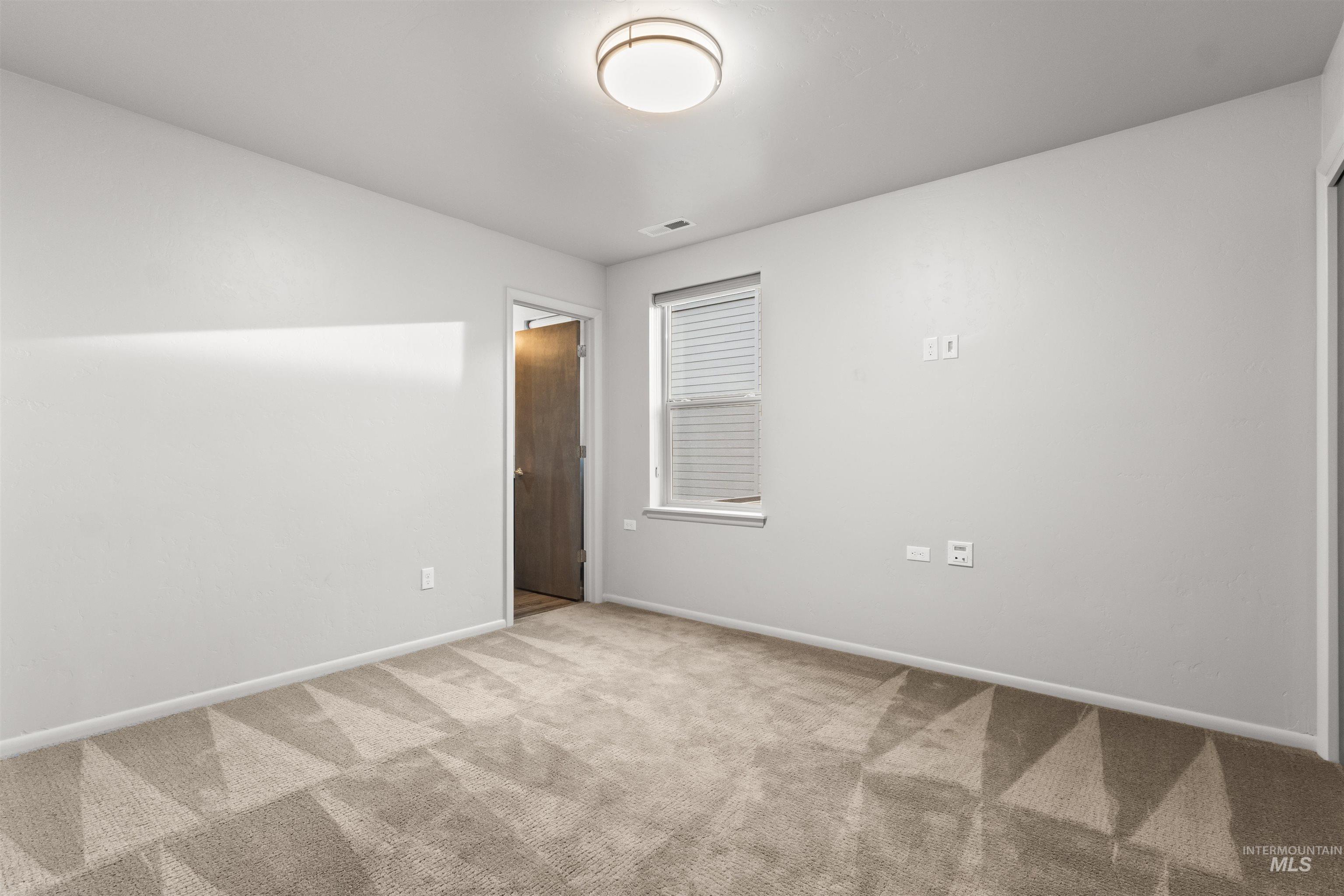Second floor bedroom featuring carpet floors and attached bathroom