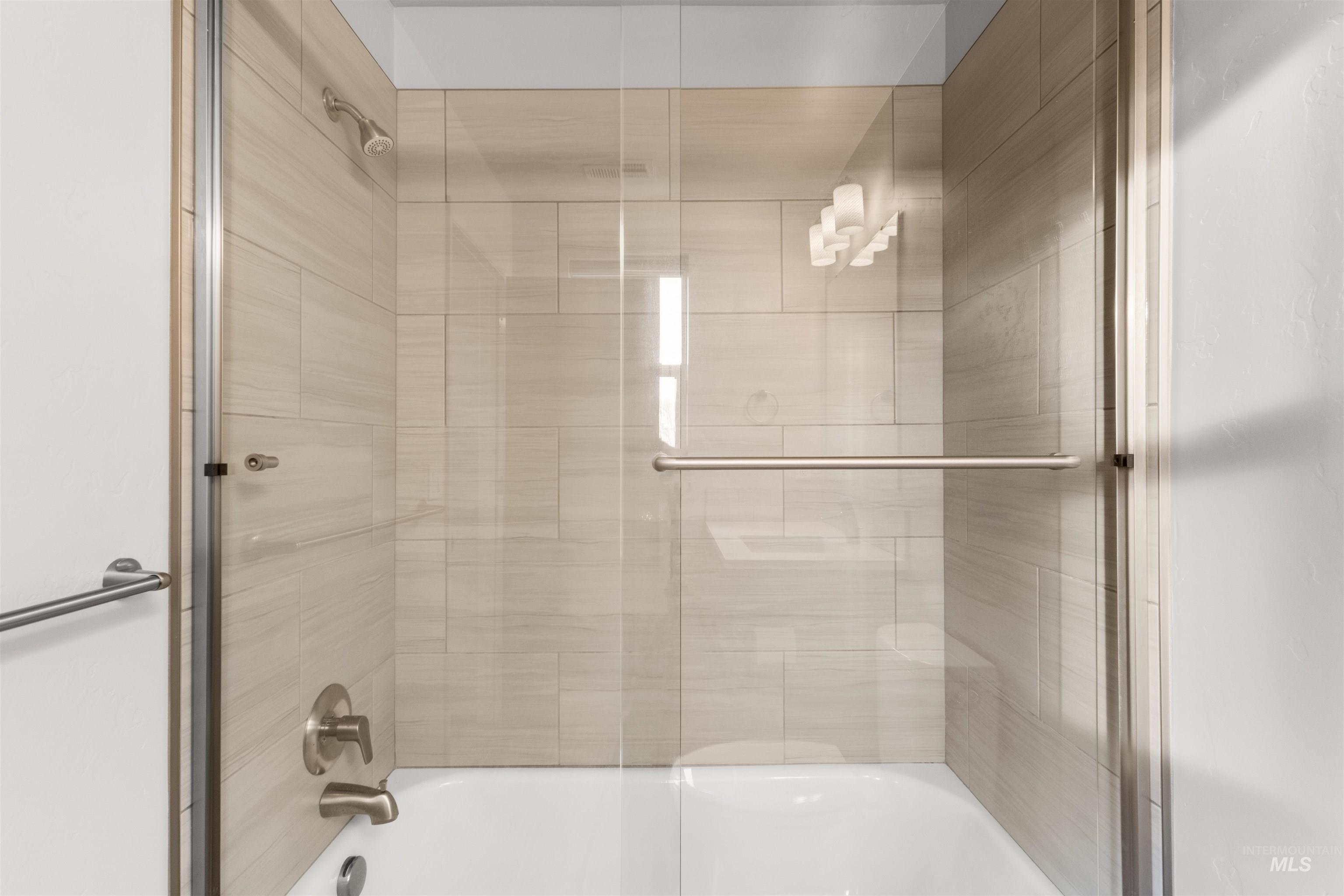 Bathroom Bathroom attached to bedroom featuring shower / bath combination with glass door