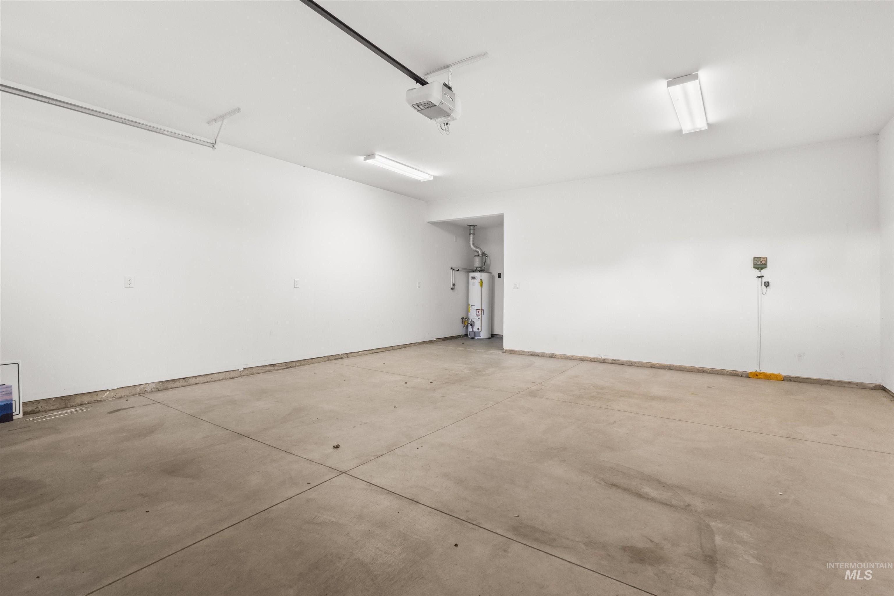 spacious 2-car garage with gas water heater and a garage door opener