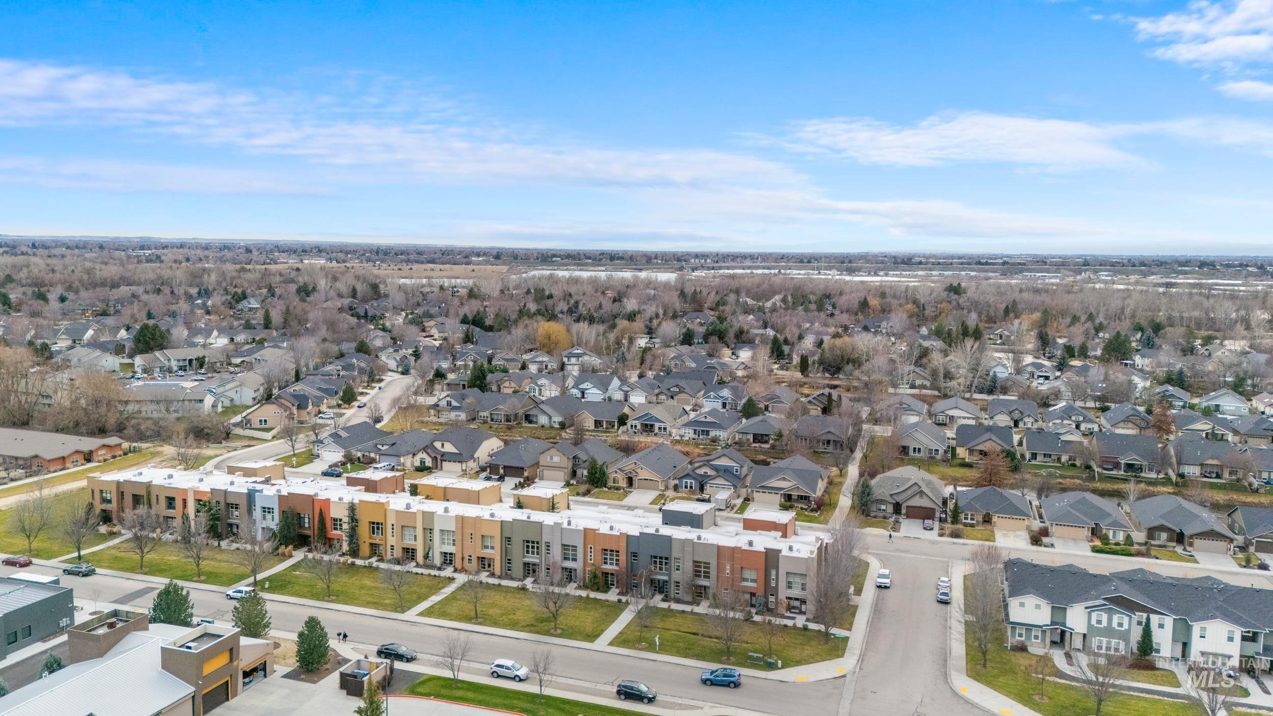 Aerial view of property and surrounding area featuring nearby suburban area