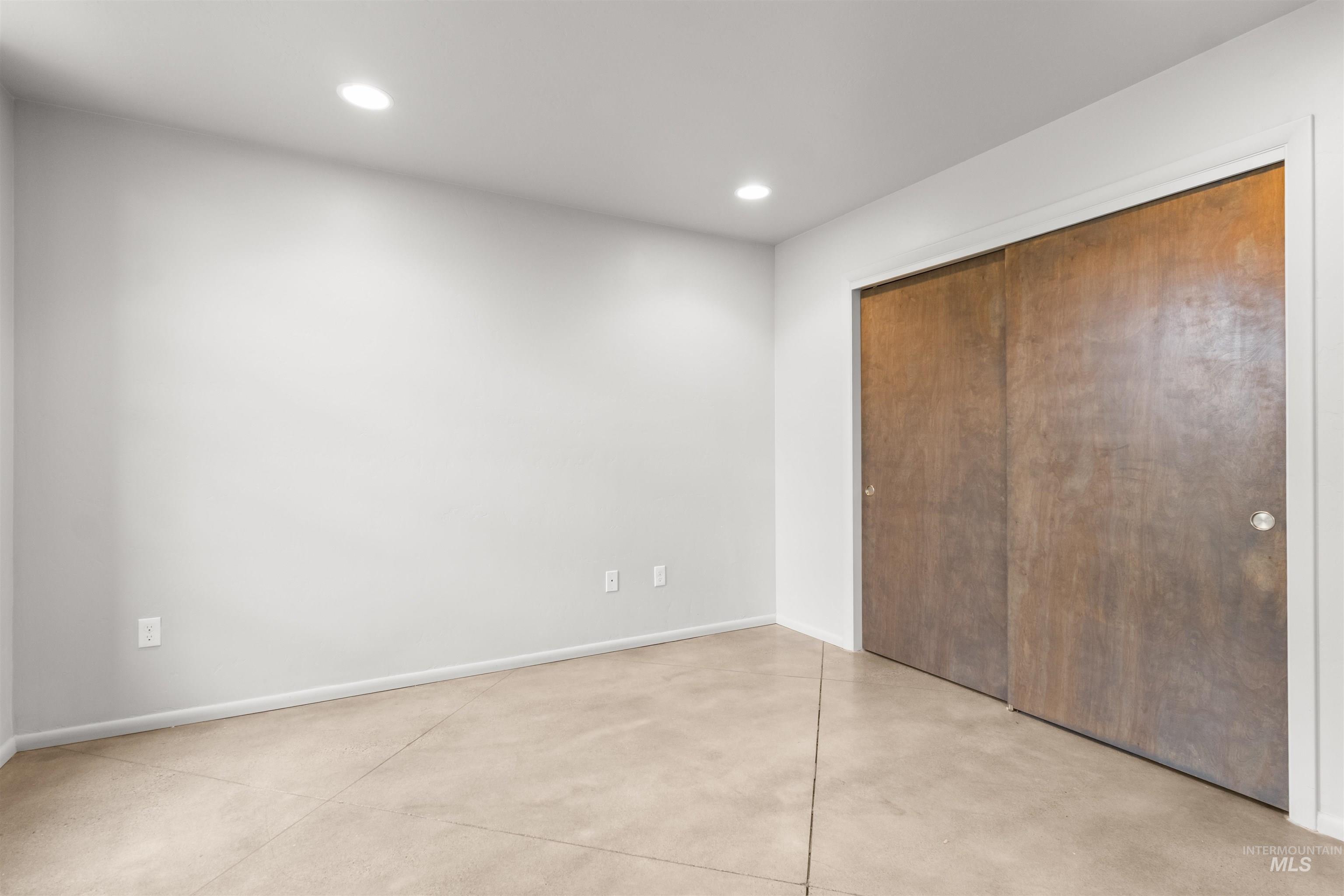 Bedroom/Flex Room featuring finished concrete floors, recessed lighting, and a closet