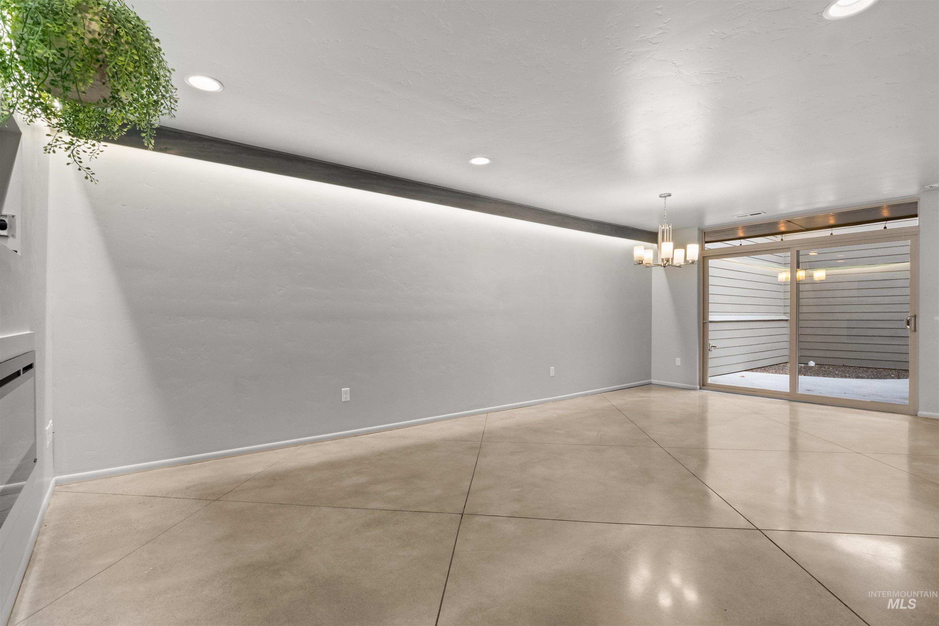Great room with recessed lighting, a chandelier over dining area, and concrete flooring