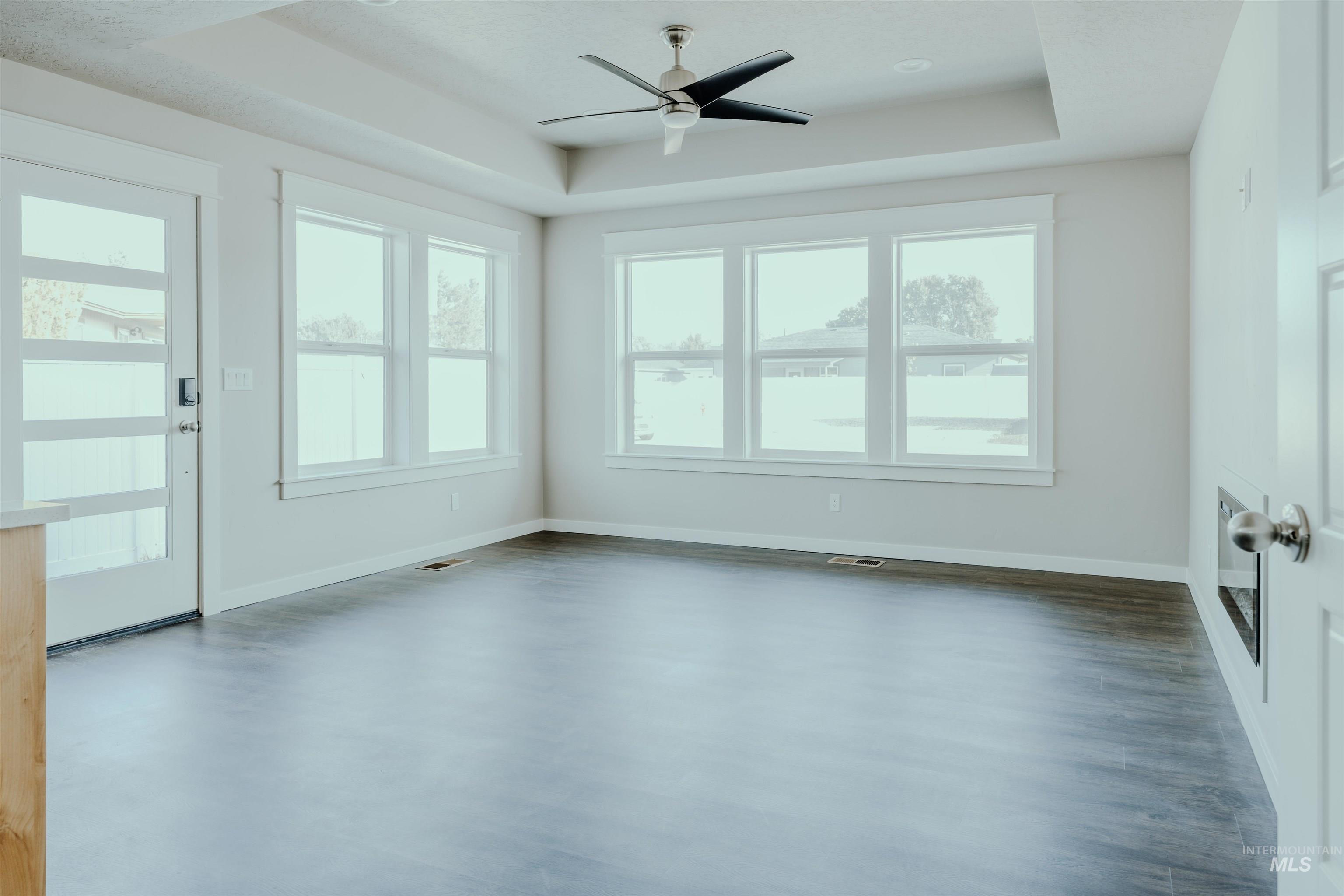 Spare room featuring a tray ceiling and a ceiling fan