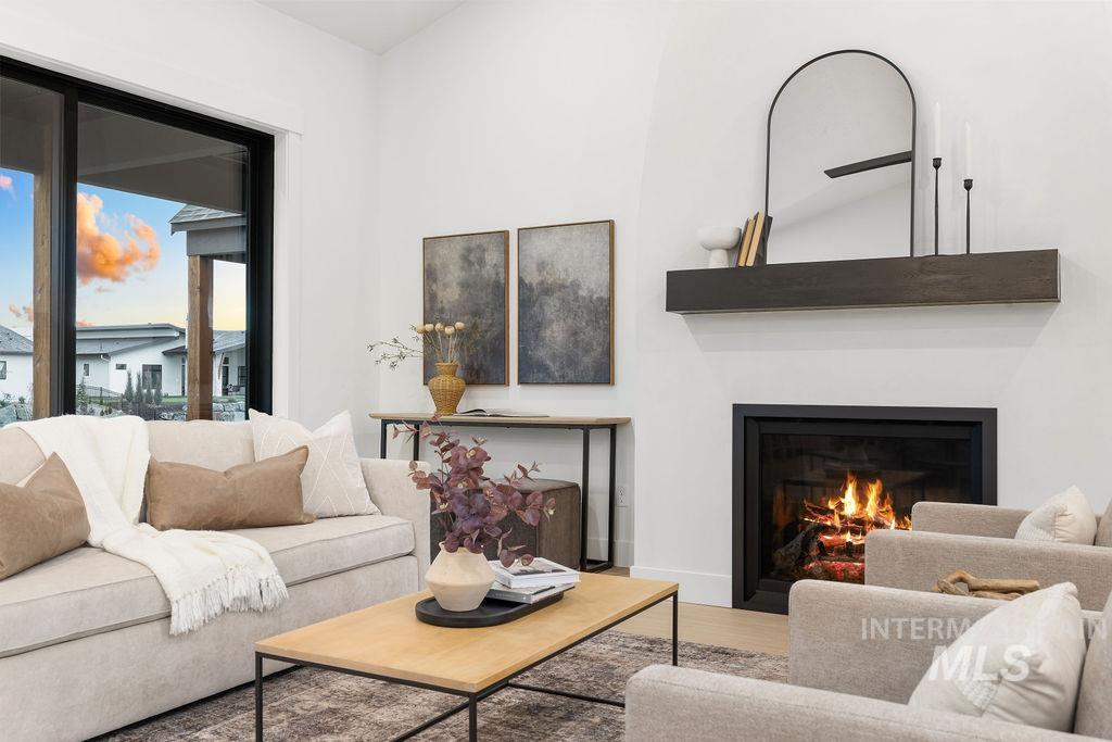 Living area with a lit fireplace and wood finished floors