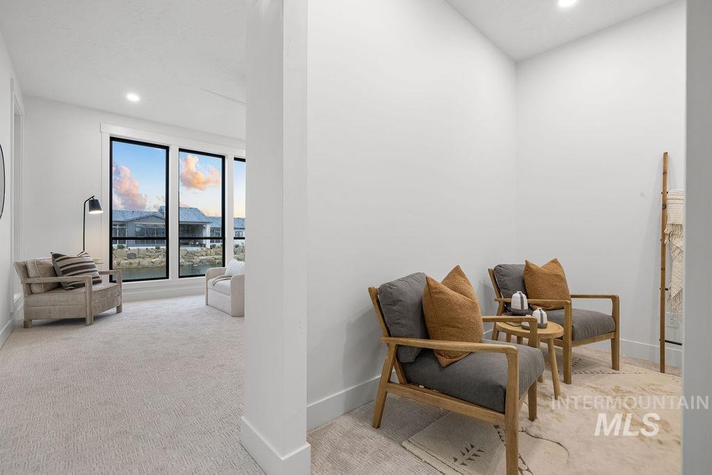 Living area with recessed lighting and light colored carpet