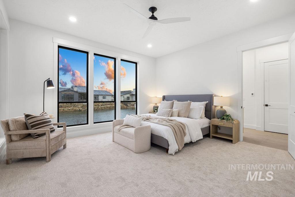 Bedroom with a water view, light colored carpet, a ceiling fan, and recessed lighting