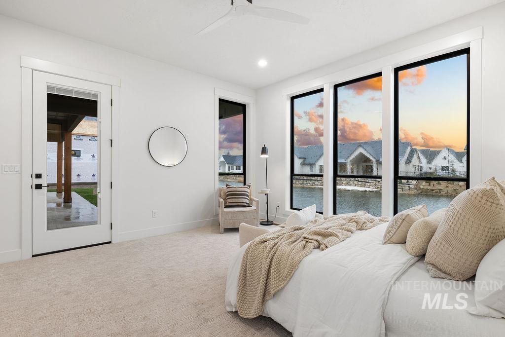 Carpeted bedroom with access to outside, a water view, a ceiling fan, and recessed lighting