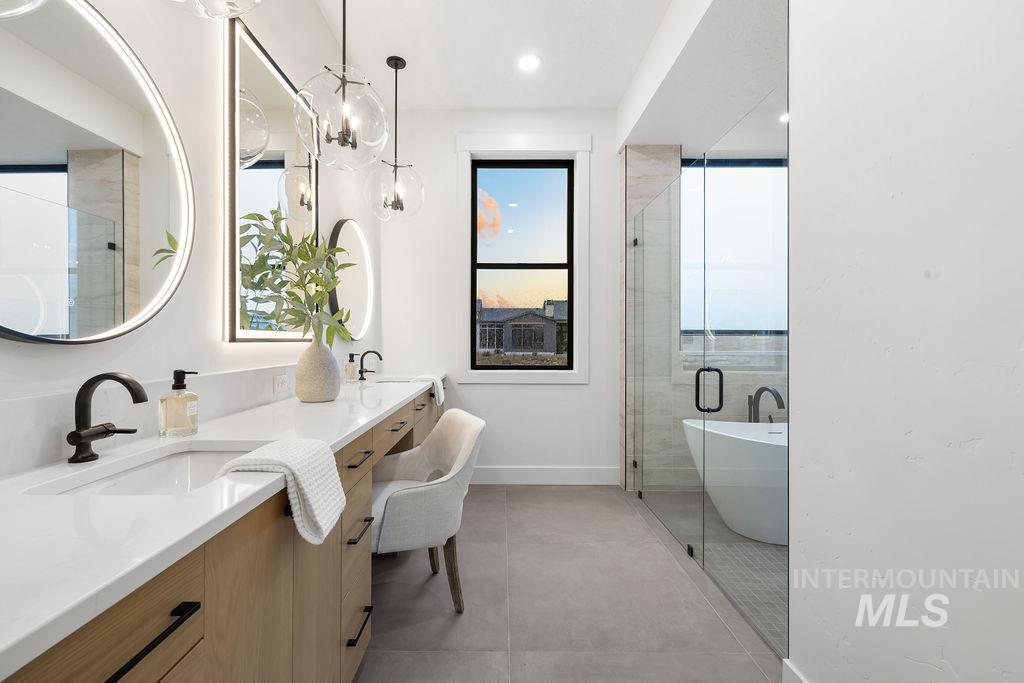 Full bathroom featuring a freestanding tub, a shower stall, double vanity, a chandelier, and recessed lighting