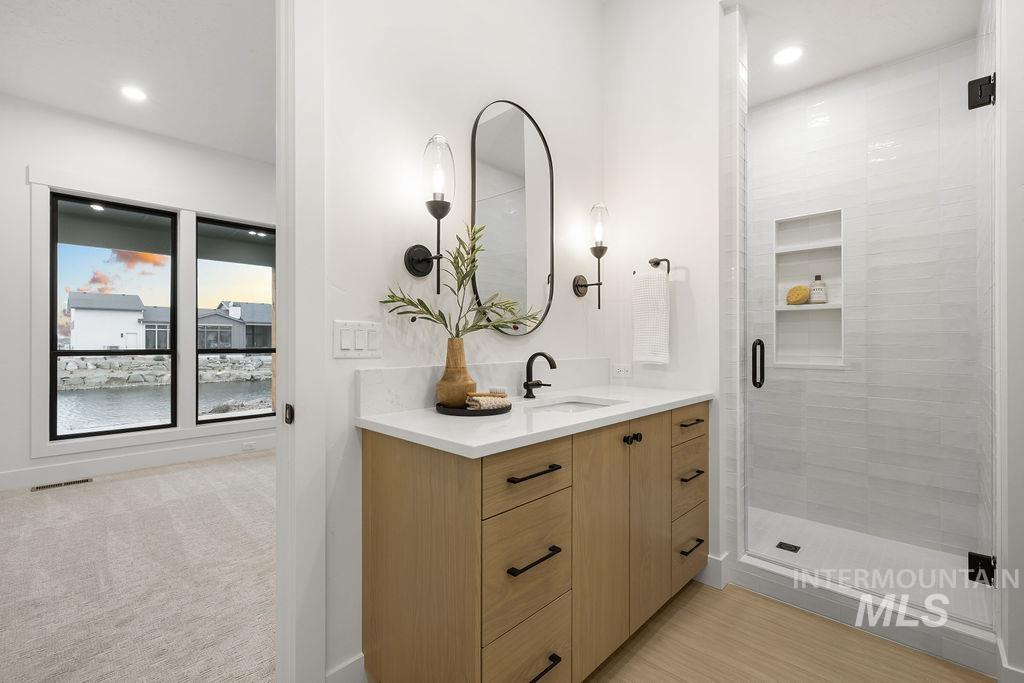 Full bath with vanity, recessed lighting, a shower stall, and light carpet