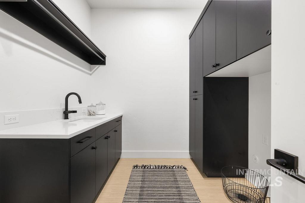 Laundry area with light wood-style floors