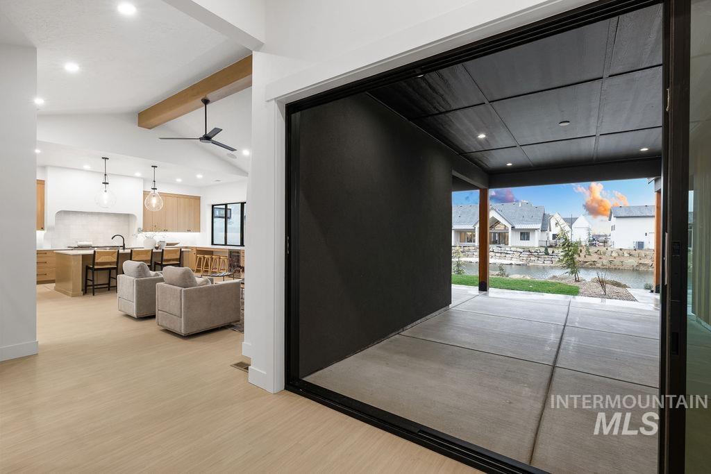Doorway featuring a water view, recessed lighting, wood finished floors, a residential view, and ceiling fan
