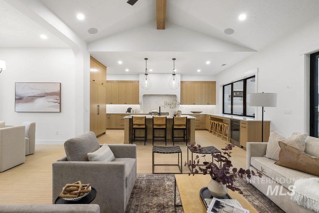 Living room featuring light wood-style flooring, beverage cooler, ceiling fan, and recessed lighting