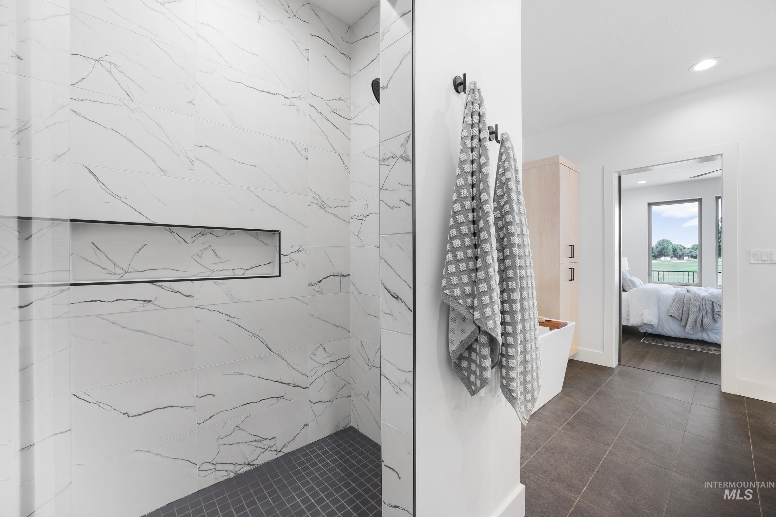 Full bath with a marble finish shower, connected bathroom, and recessed lighting