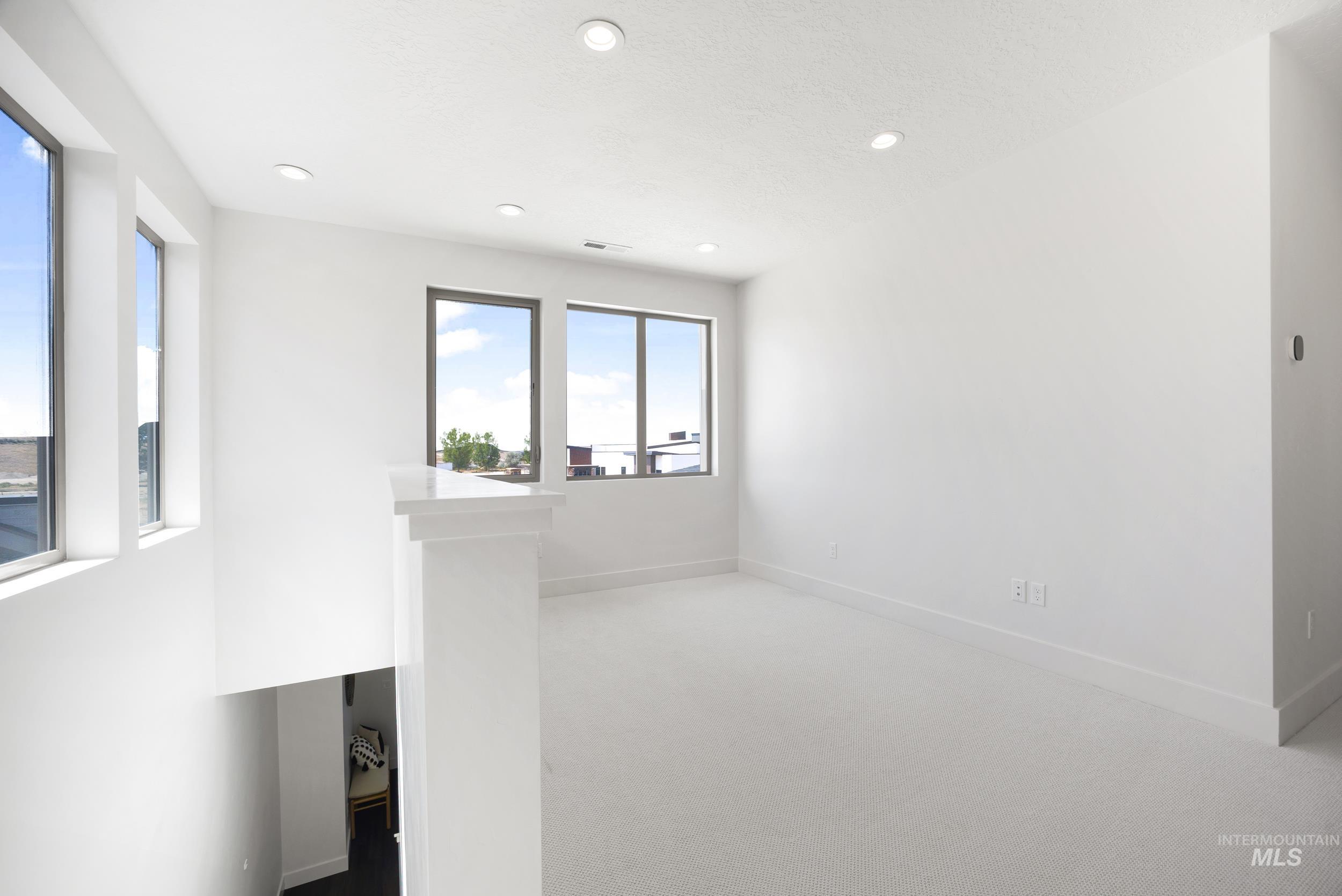 Spare room with light carpet and recessed lighting