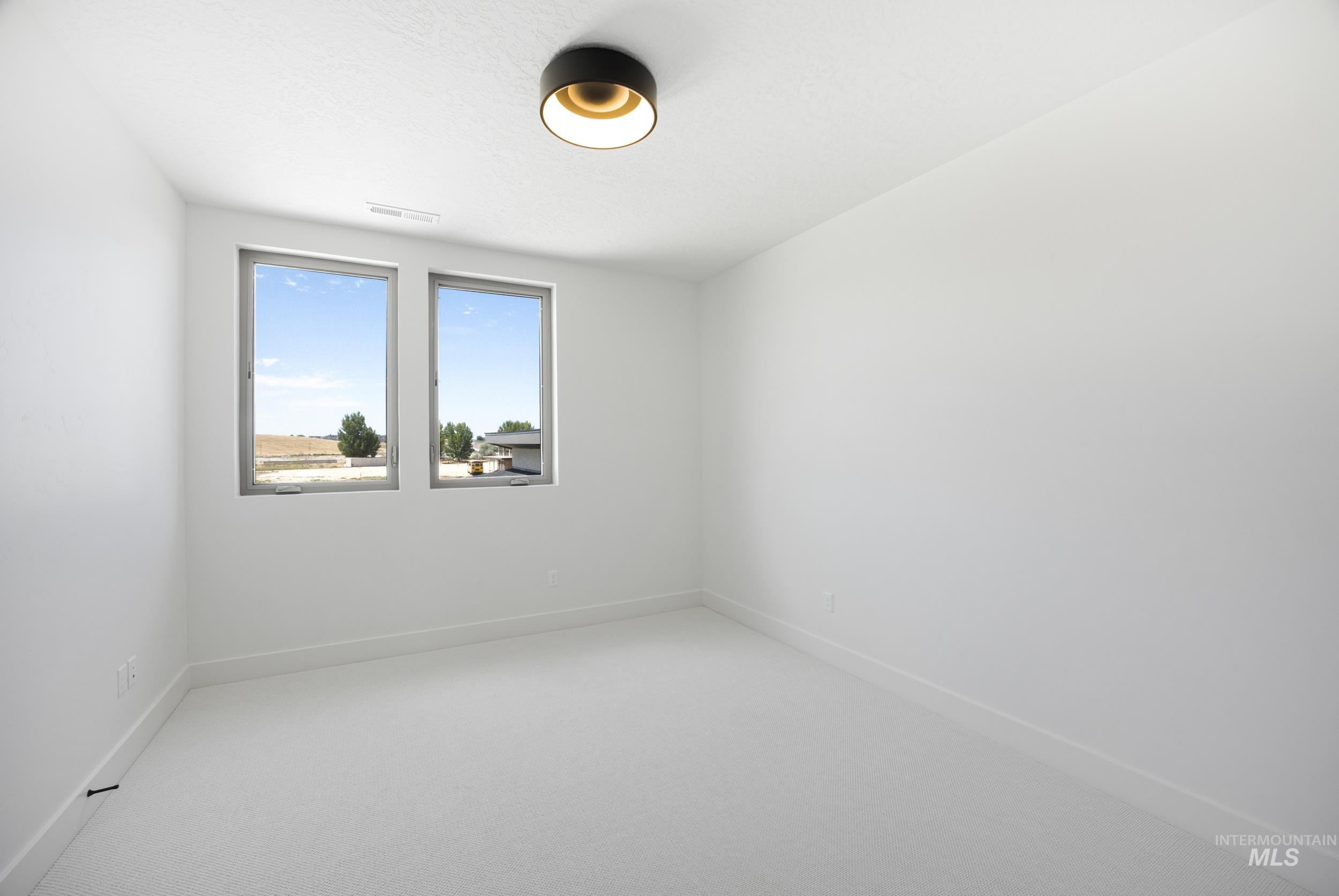Empty room featuring carpet flooring and baseboards