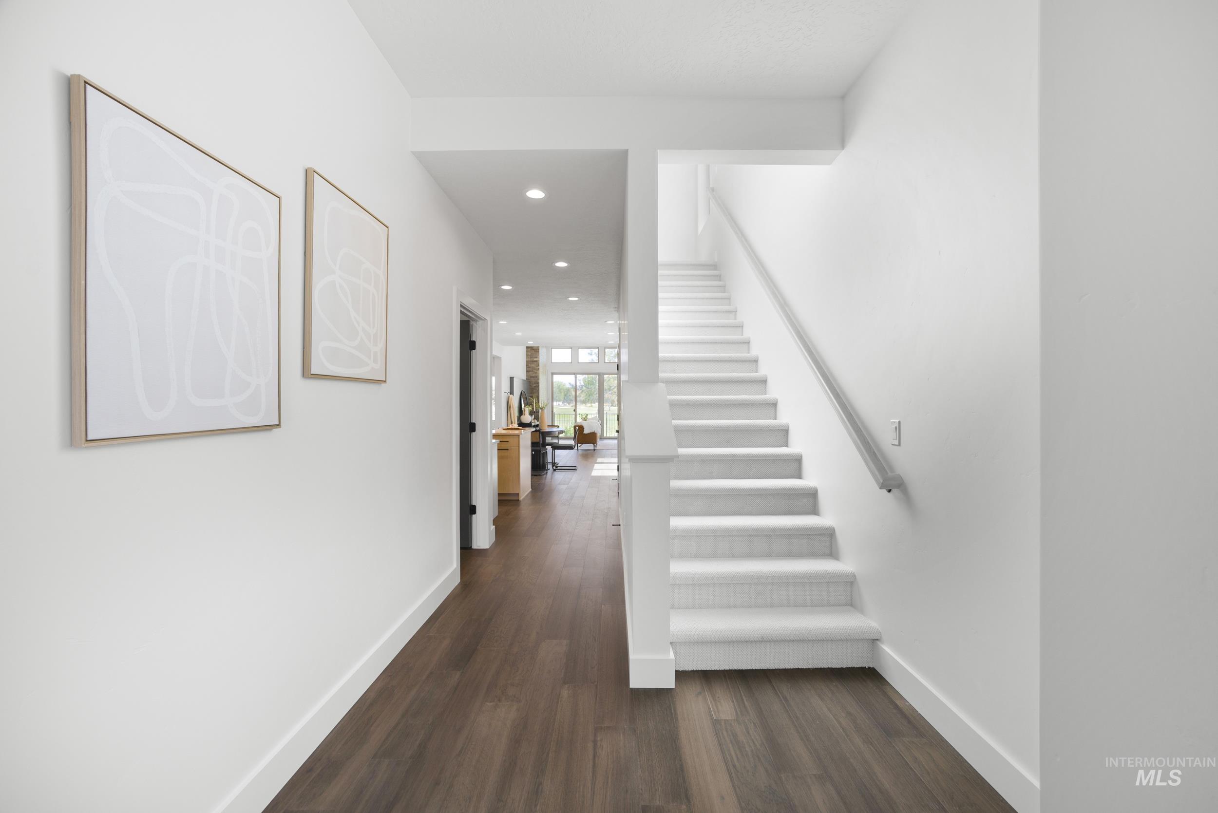 Corridor featuring dark wood-type flooring, stairs, and recessed lighting