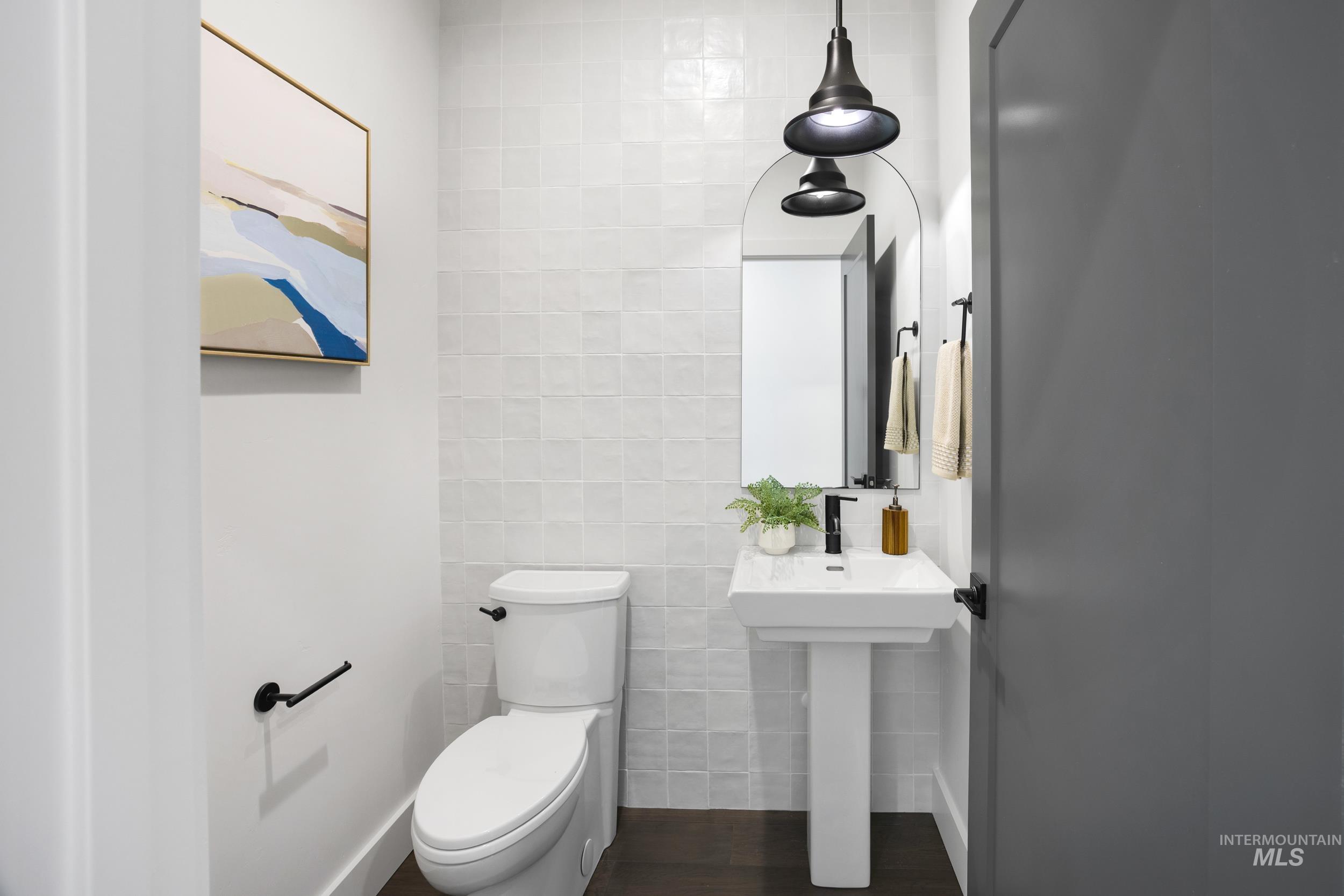 Bathroom with tile walls and dark wood-style floors