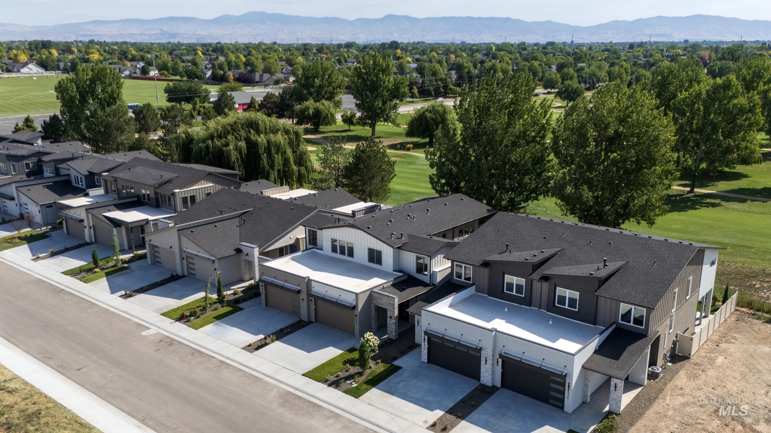 Aerial view of residential area with a golf course and a mountain backdrop