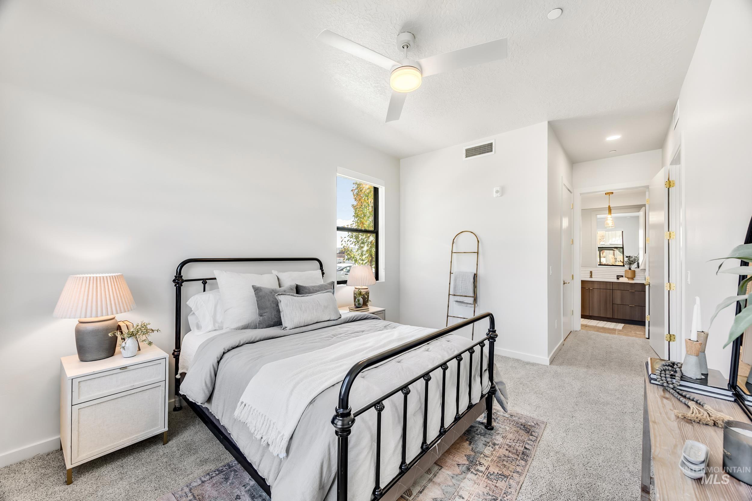 Bedroom with ceiling fan, light colored carpet, ensuite bathroom, recessed lighting, and a textured ceiling