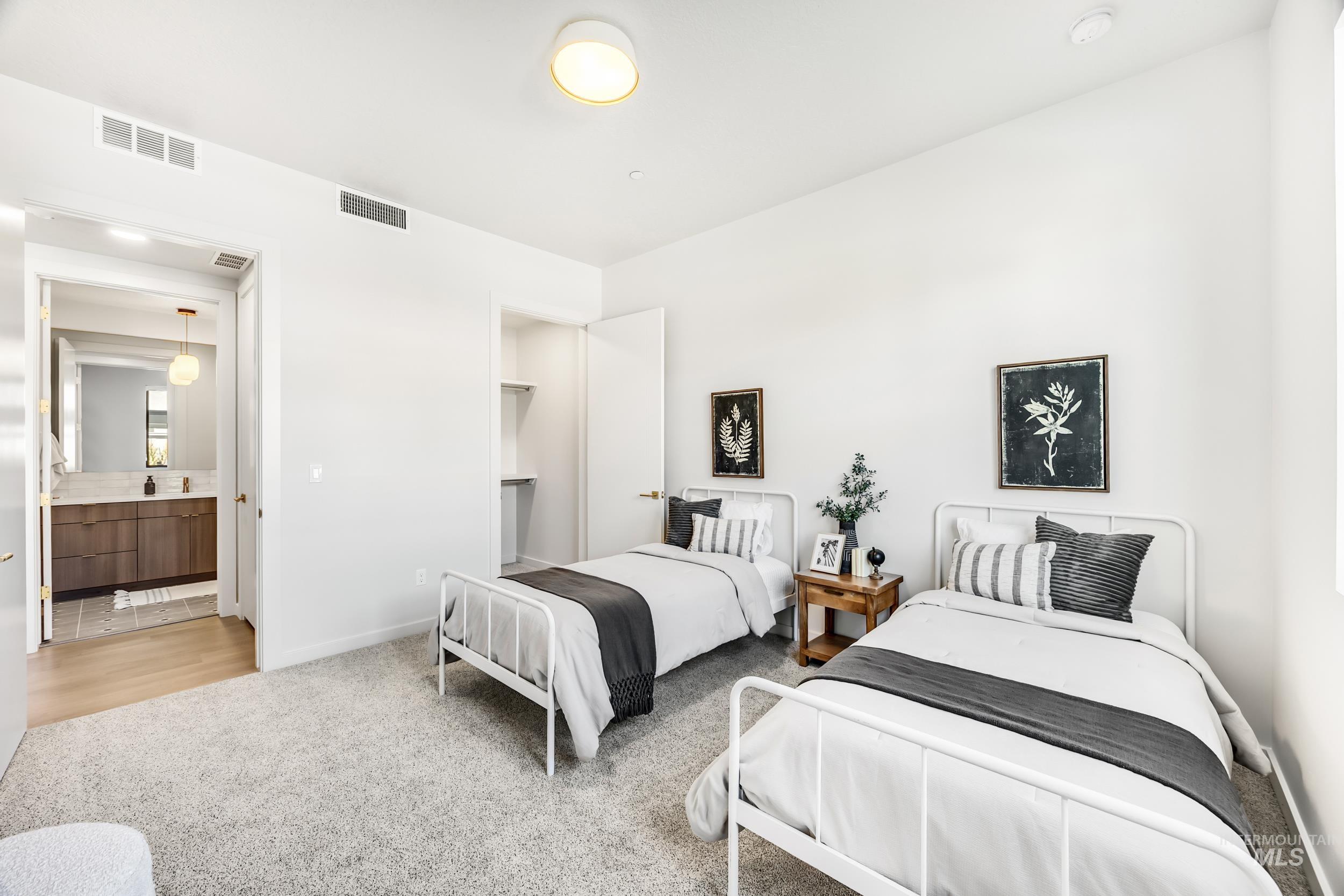 Bedroom with light colored carpet and ensuite bath