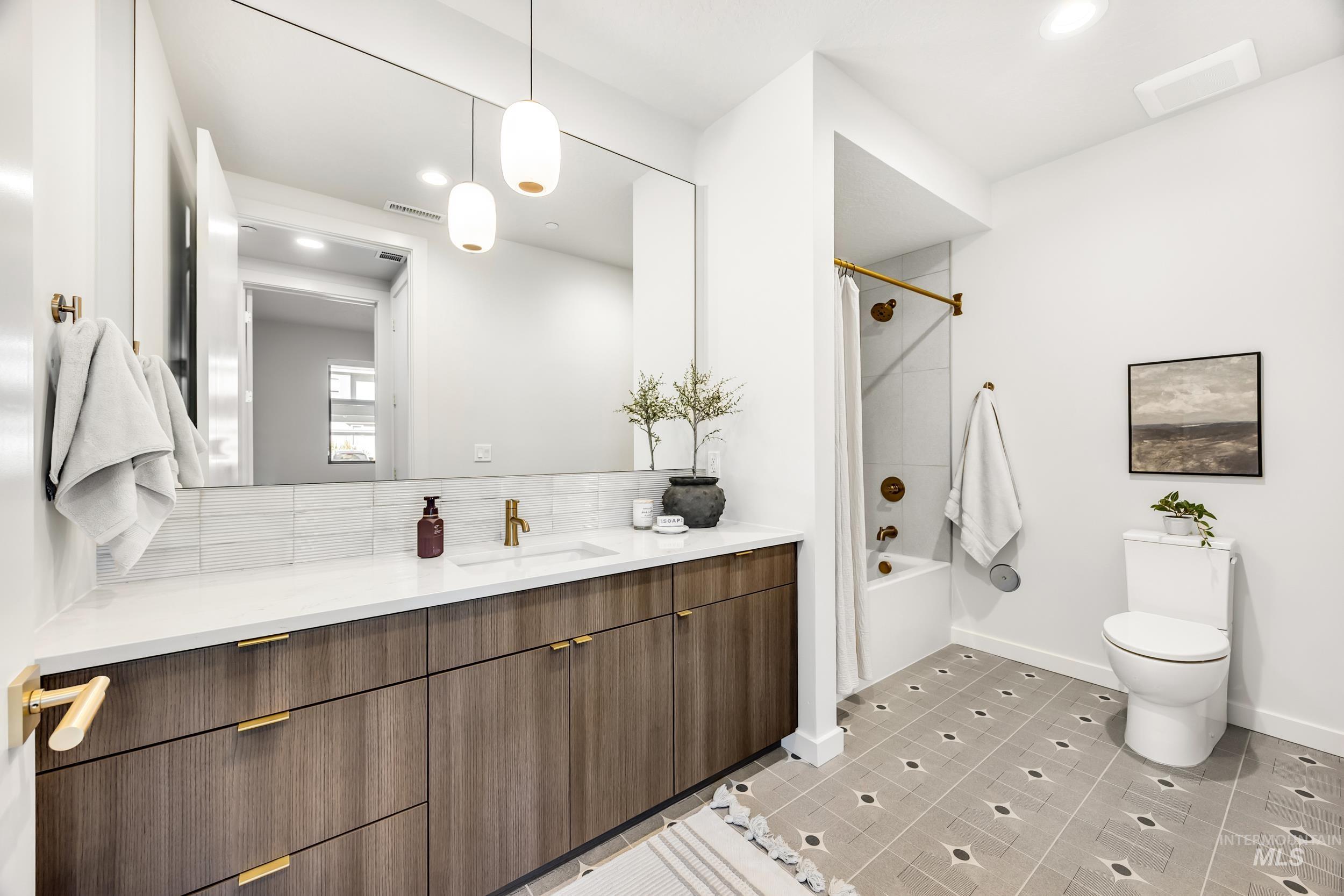 Bathroom with vanity, shower / bath combination, light tile patterned floors, and recessed lighting