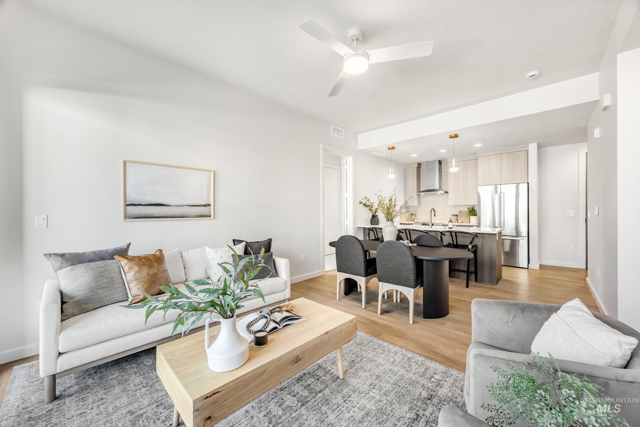 Living room with light wood finished floors and ceiling fan