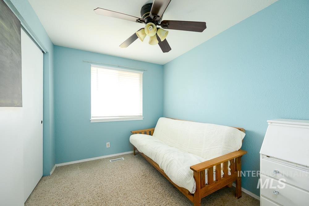 Carpeted bedroom featuring a ceiling fan and a closet