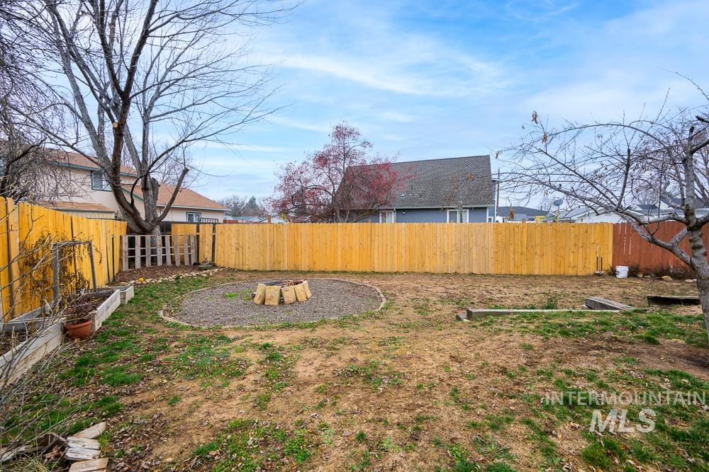 Fenced backyard featuring a fire pit