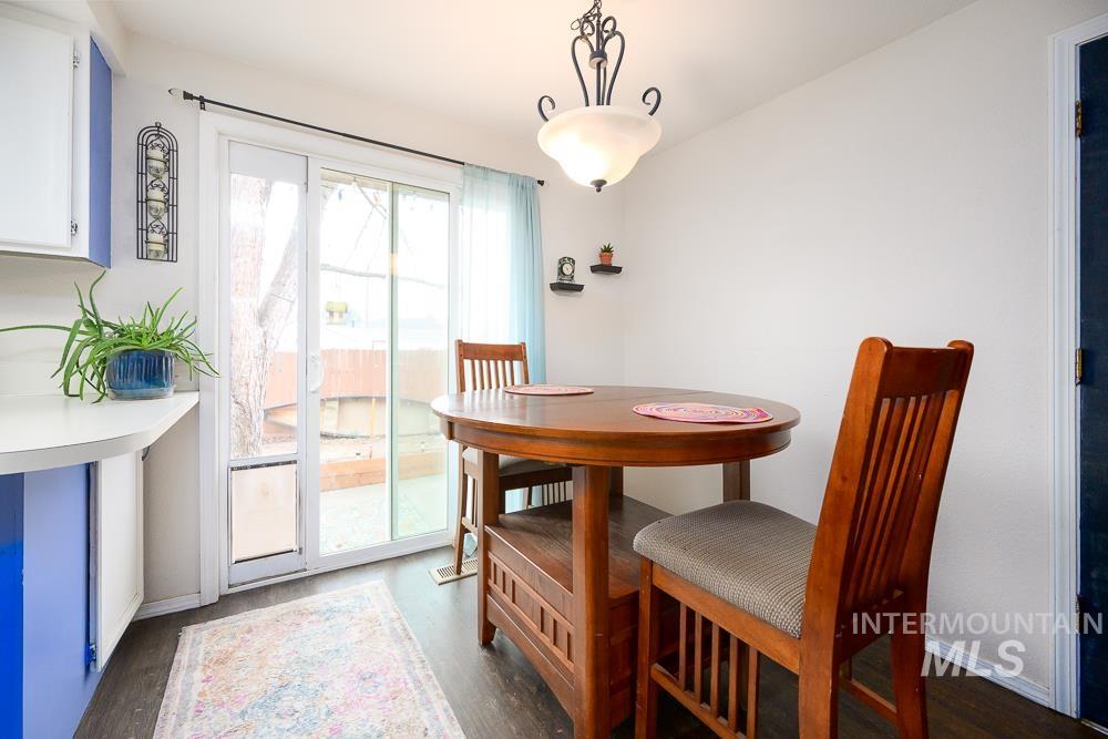 Dining area with dark wood-type flooring and baseboards