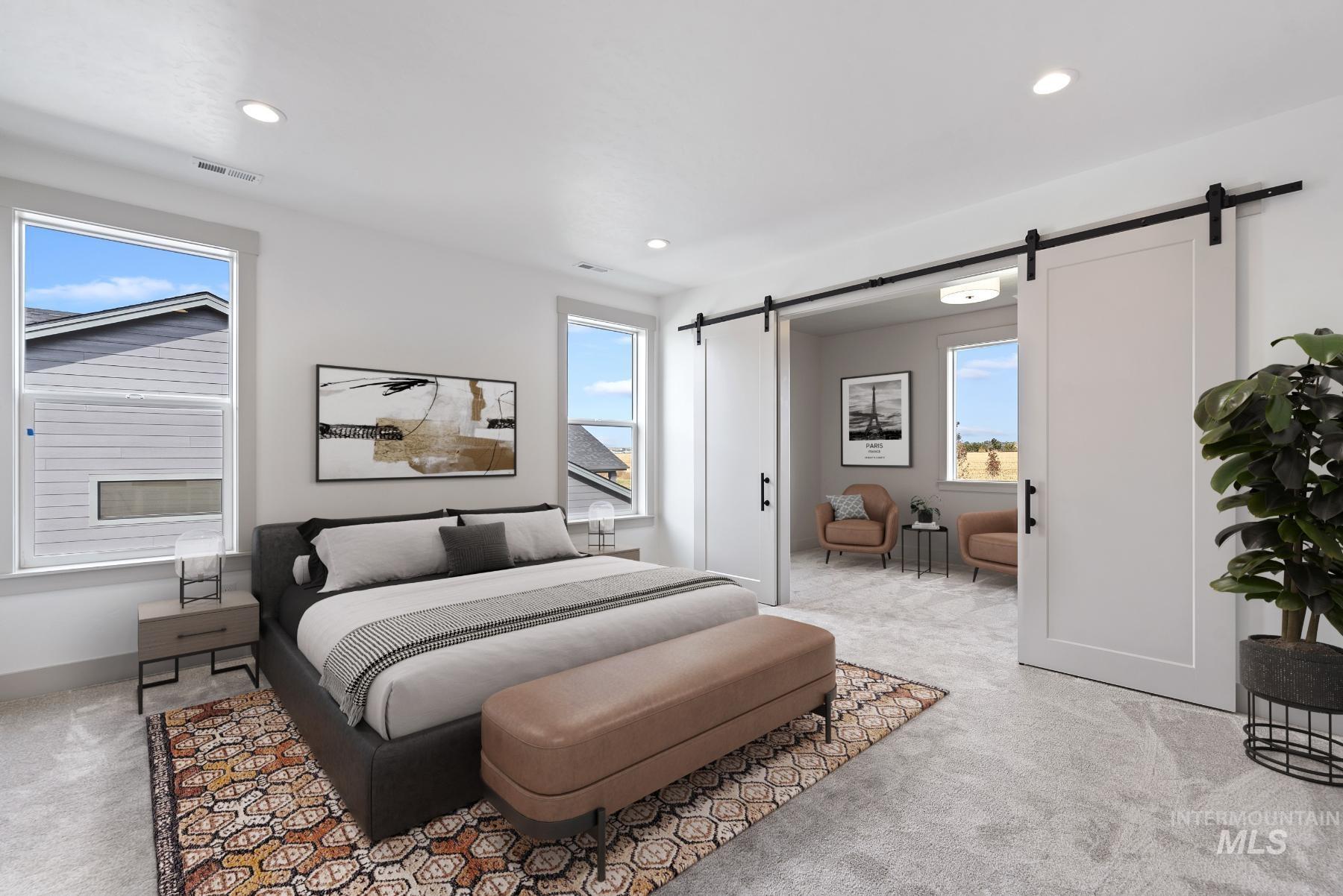 Bedroom featuring a barn door, light colored carpet, multiple windows, and recessed lighting